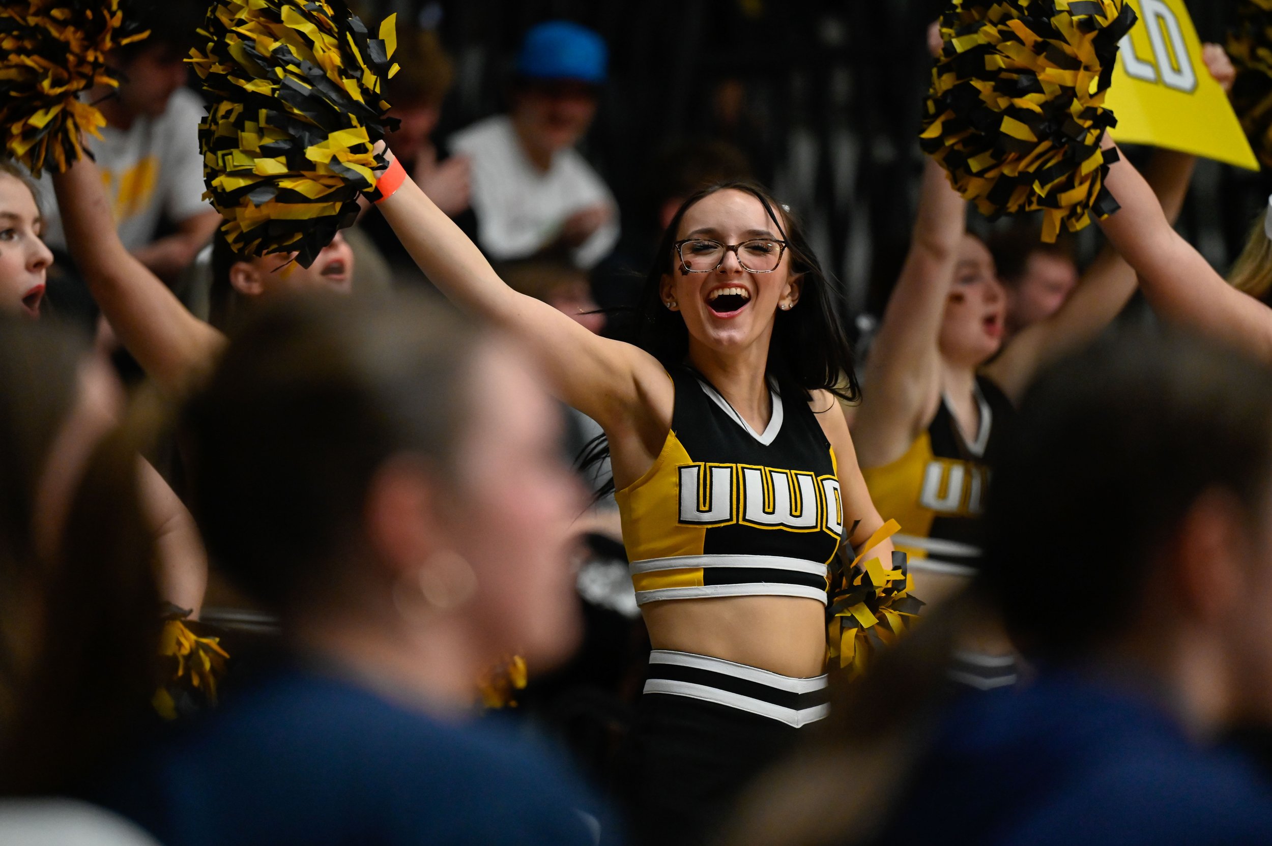 Arianna DePaolo, a cheerleader for the UW-Oshkosh Cheer and Stunt team, waves her pompoms during a timeout at Kolf Sports Center in Oshkosh, Wisconsin on March 7, 2025. The Cheer and Stunt team cheers at every UWO home basketball game that runs from