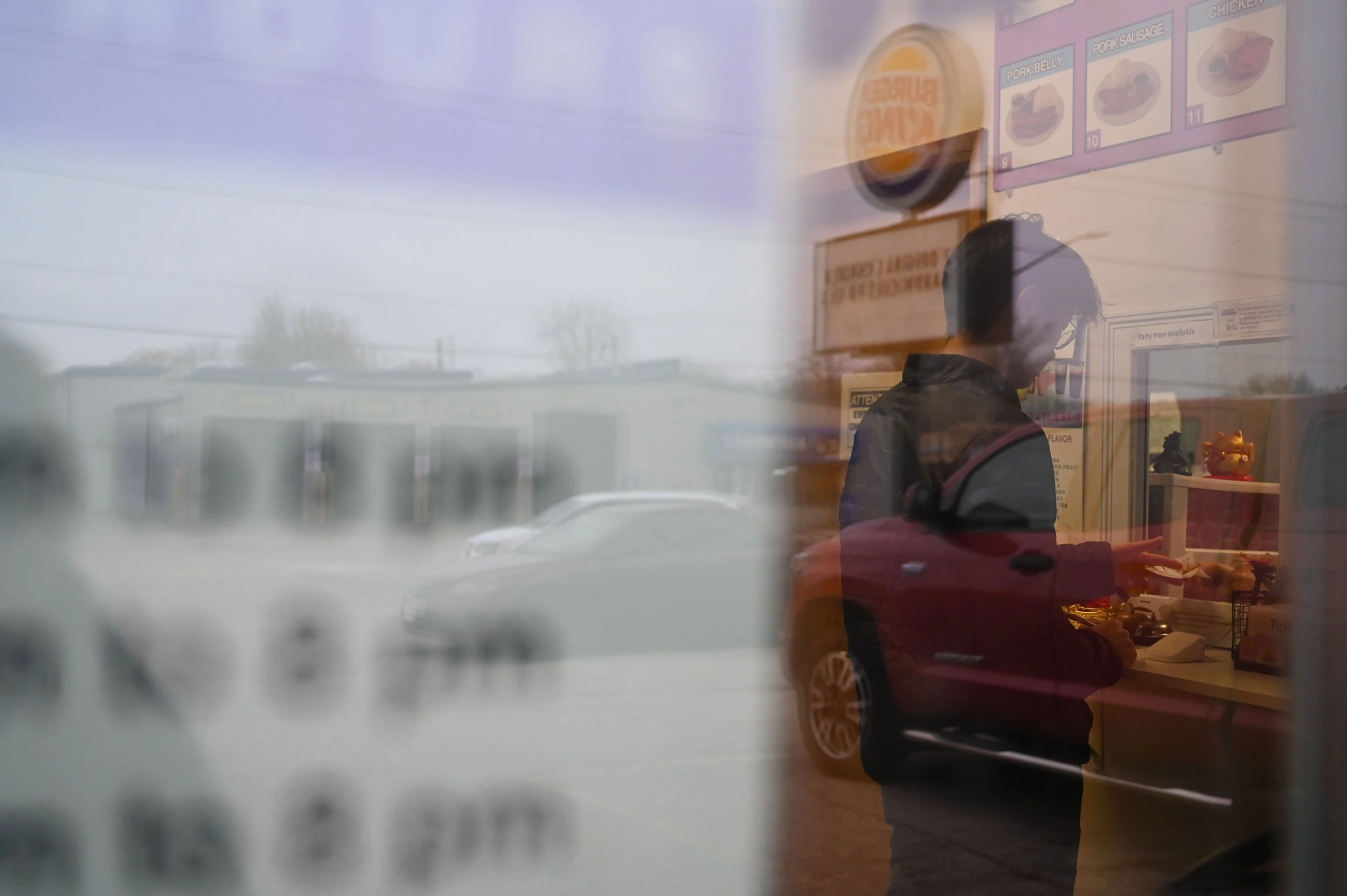 Surrounded by corporate American businesses such as Burger King, Kenneth Lee grabs a receipt after paying for food at his favorite Hmong restaurant in Appleton, Lo Yuhmie in Appleton, Wis., Thursday, March 12, 2026. Though Lee and his mother, Yami Sw