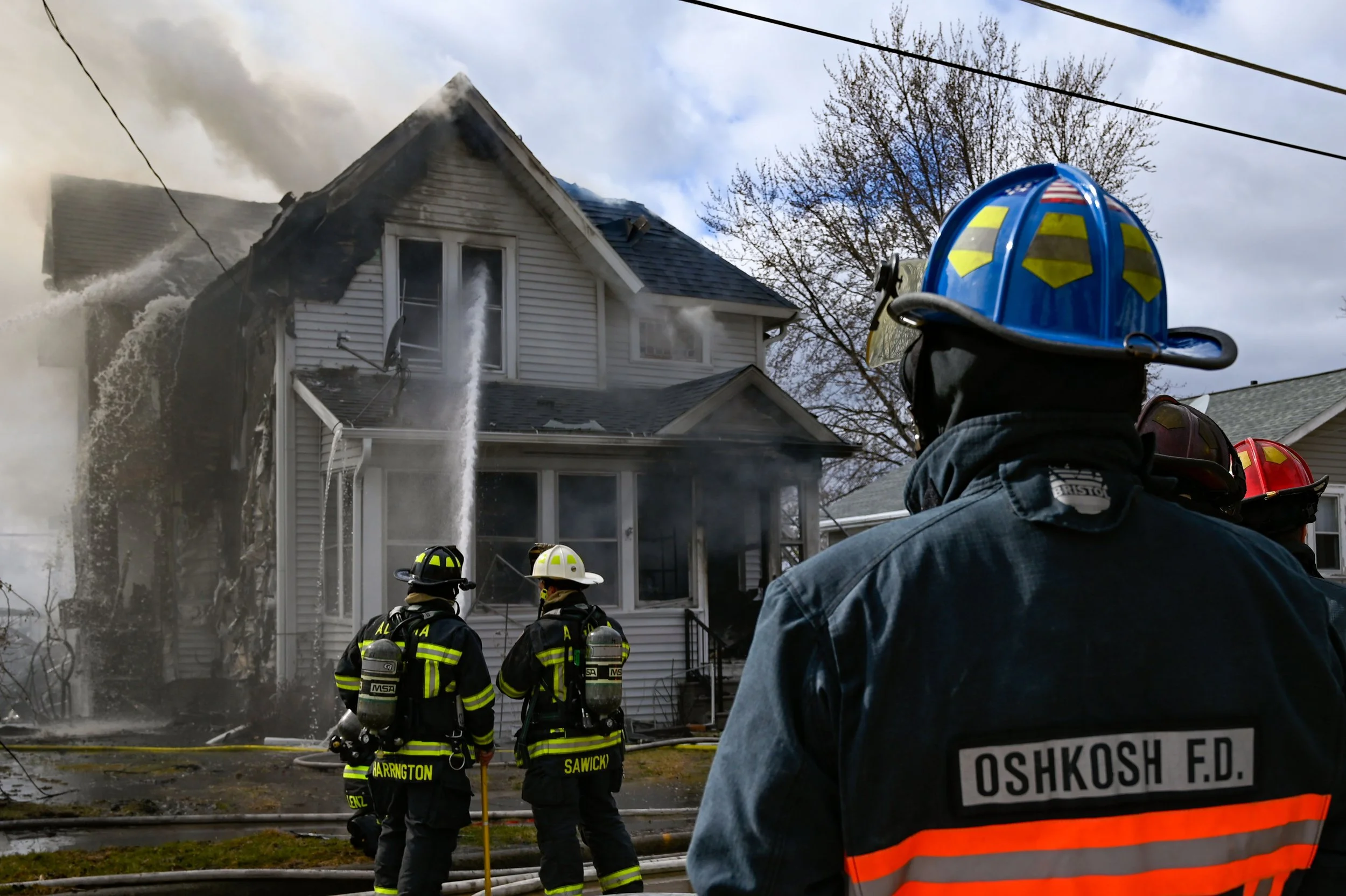 A firefighter watches as crews work to extinguish a blaze at 1313 Liberty Street, Oshkosh, Wis., on March 31, 2025. The home was a complete loss after the fire. 