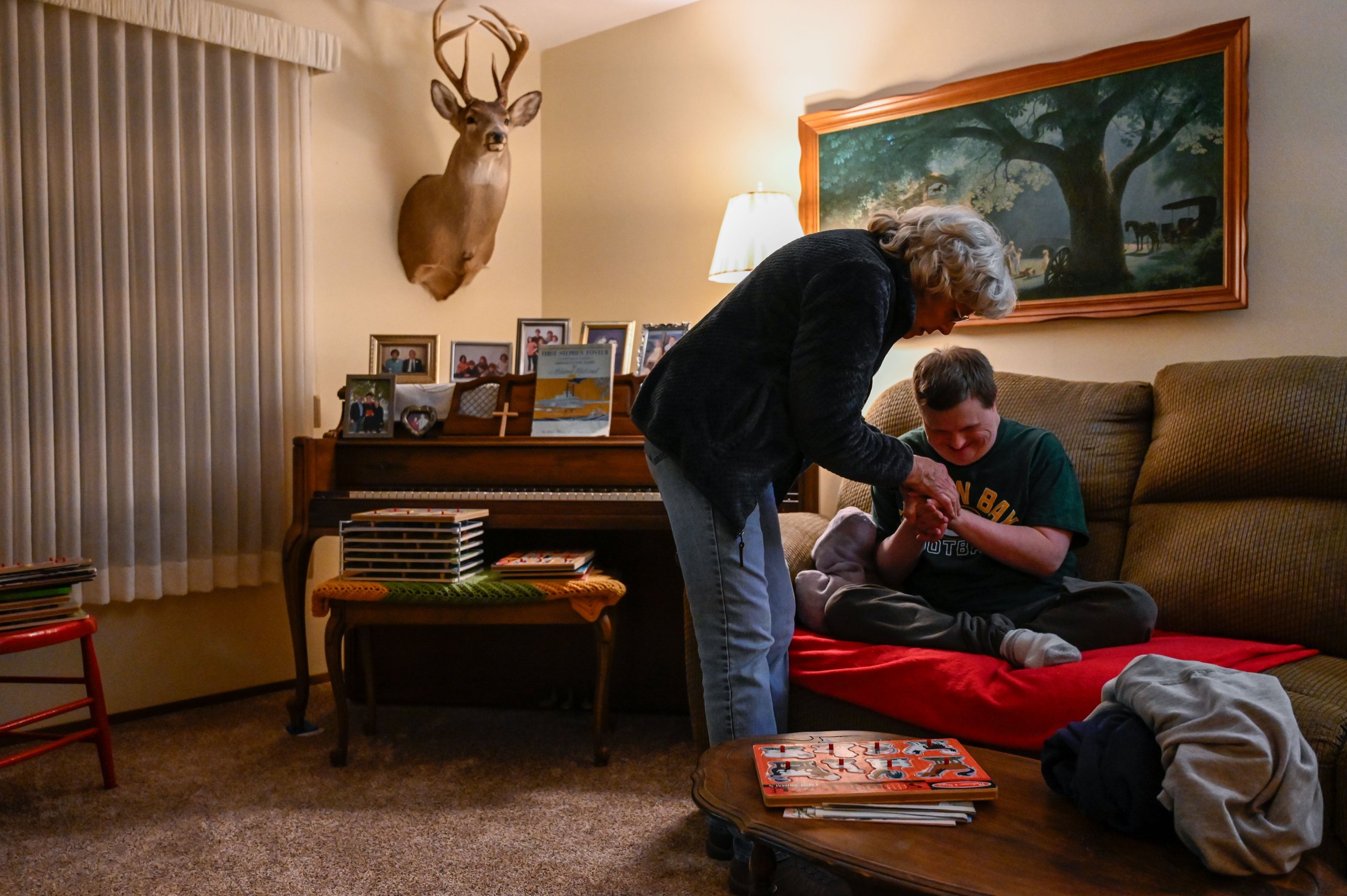 While Janet tries to get Chad up to brush his teeth and get ready for bed, he squeezes her hands with his. Janet also brought the clothes on the table in front of them for Chad to change into. 