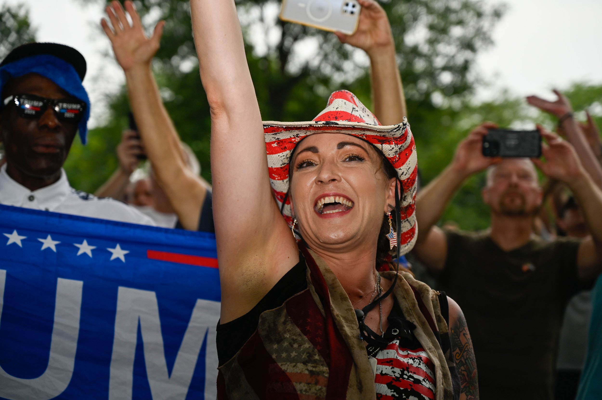 A live streamer for social media accounts under the name "Soup Mama Official" cheers and waves as U.S. Army soldiers march through the military parade in Washington, D.C., on June 14, 2025. Soup Mama Official states they are a "501(c)3 non-profit, no