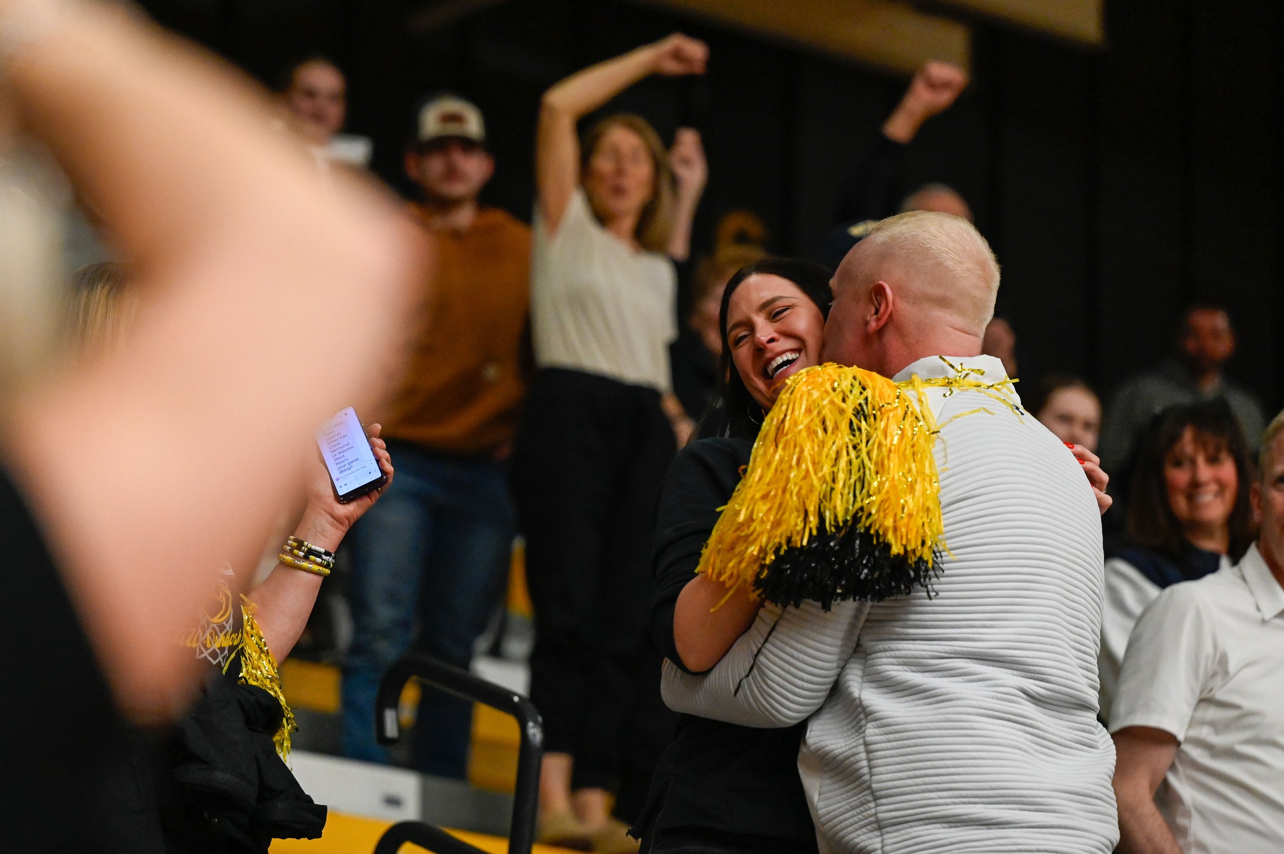 Brad Fischer, the head coach for the UW-Oshkosh women's basketball team, plants a celebratory kiss on the cheek of his wife, Lisa Fischer's, moments after his team defeated Bethel University at Kolf Sports Center in Oshkosh, Wisconsin on March 8, 202