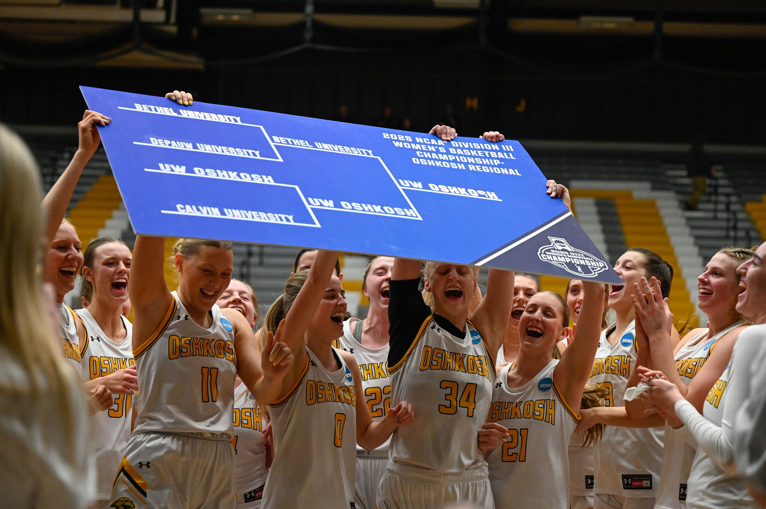 The UW-Oshkosh women's basketball team cheers with a sign that shows their bracket in the NCAA Division III tournament at Kolf Sports Center in Oshkosh, Wisconsin on March 8, 2025. The team celebrated after they made it to the Sweet 16 of the 2025 NC