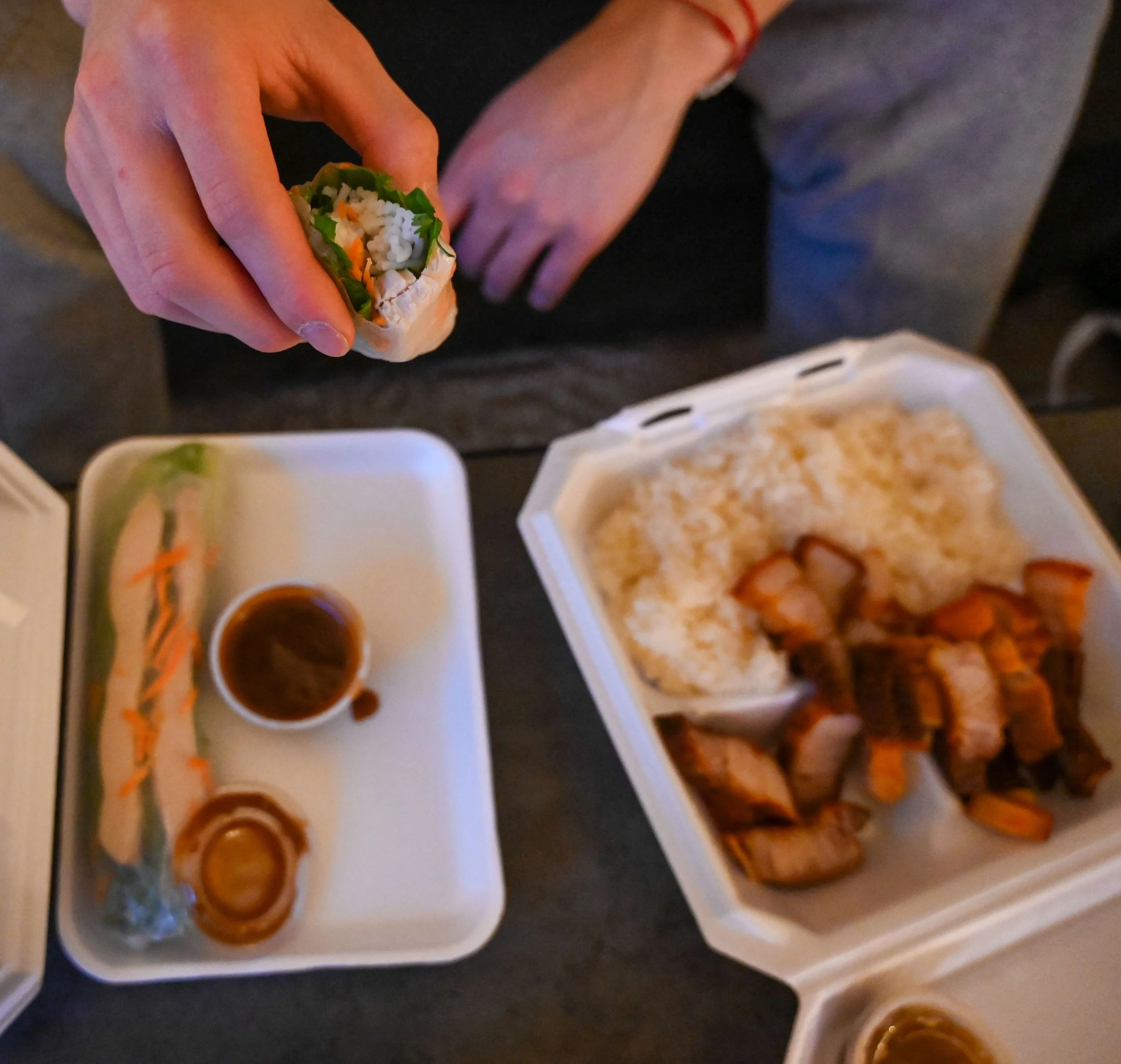 Kenneth Lee eats Hmong takeout from Lo Yumhmie Foods in Appleton, Wis., Thursday, March 12, 2026. Though Lee and his mother, Yami Sweeny, aren't very involved in the Hmong community, Lee said he feels most attached to the food.