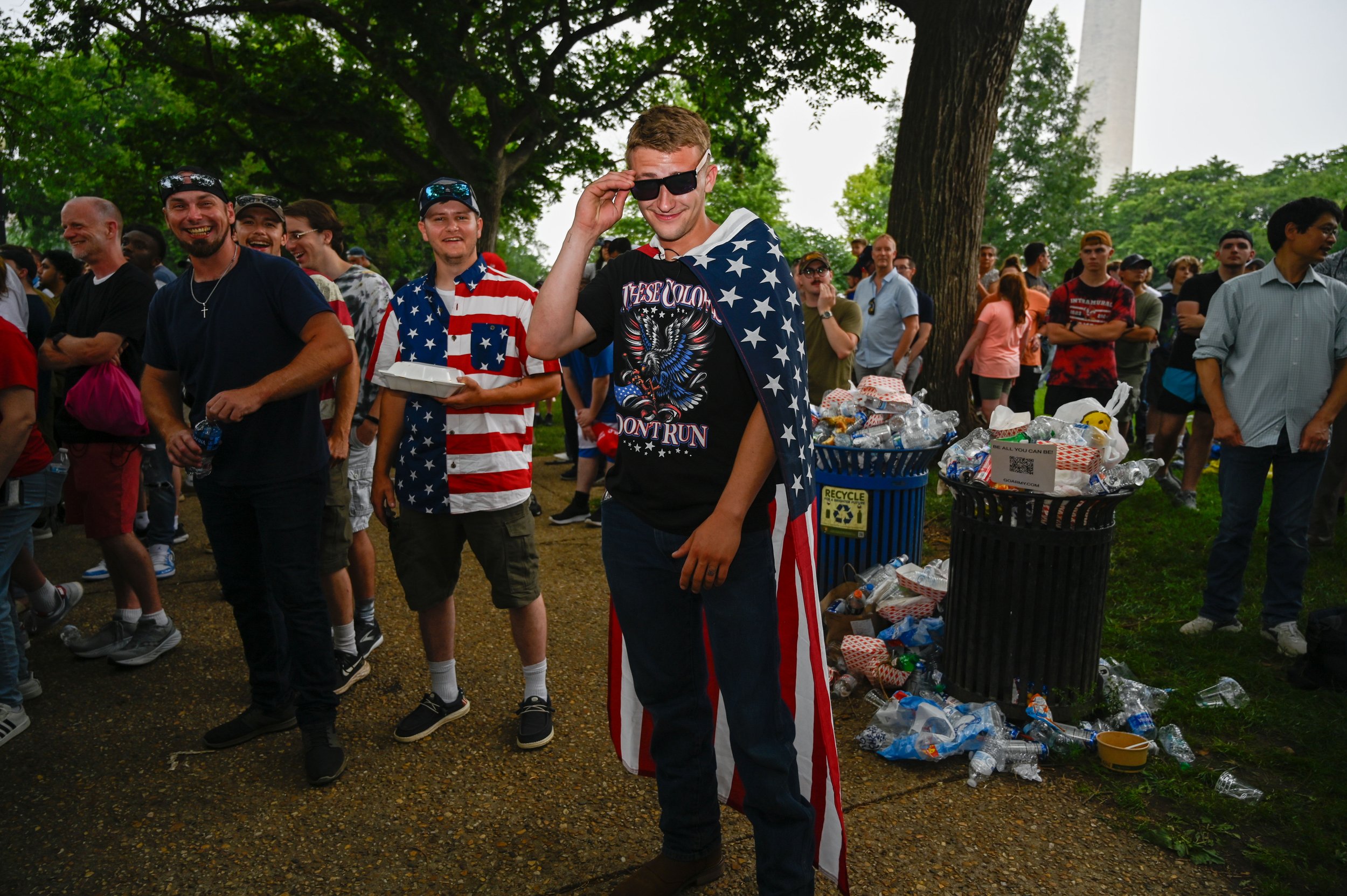 A man poses for a photo while wearing an American flag during the Army's 250th birthday celebration in Washington, D.C., on June 14, 2025.