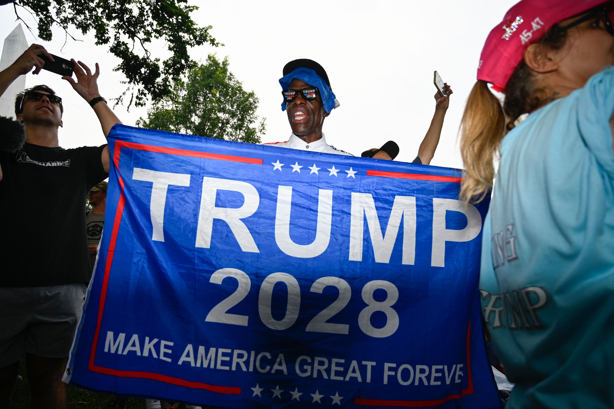 A man poses with a "Trump 2028" flag during the Army's 250th birthday celebration in Washington, D.C., on June 14, 2025. Earlier that day, the man shouted as he walked around looking for "fake news" and continued yelling when he found members of the