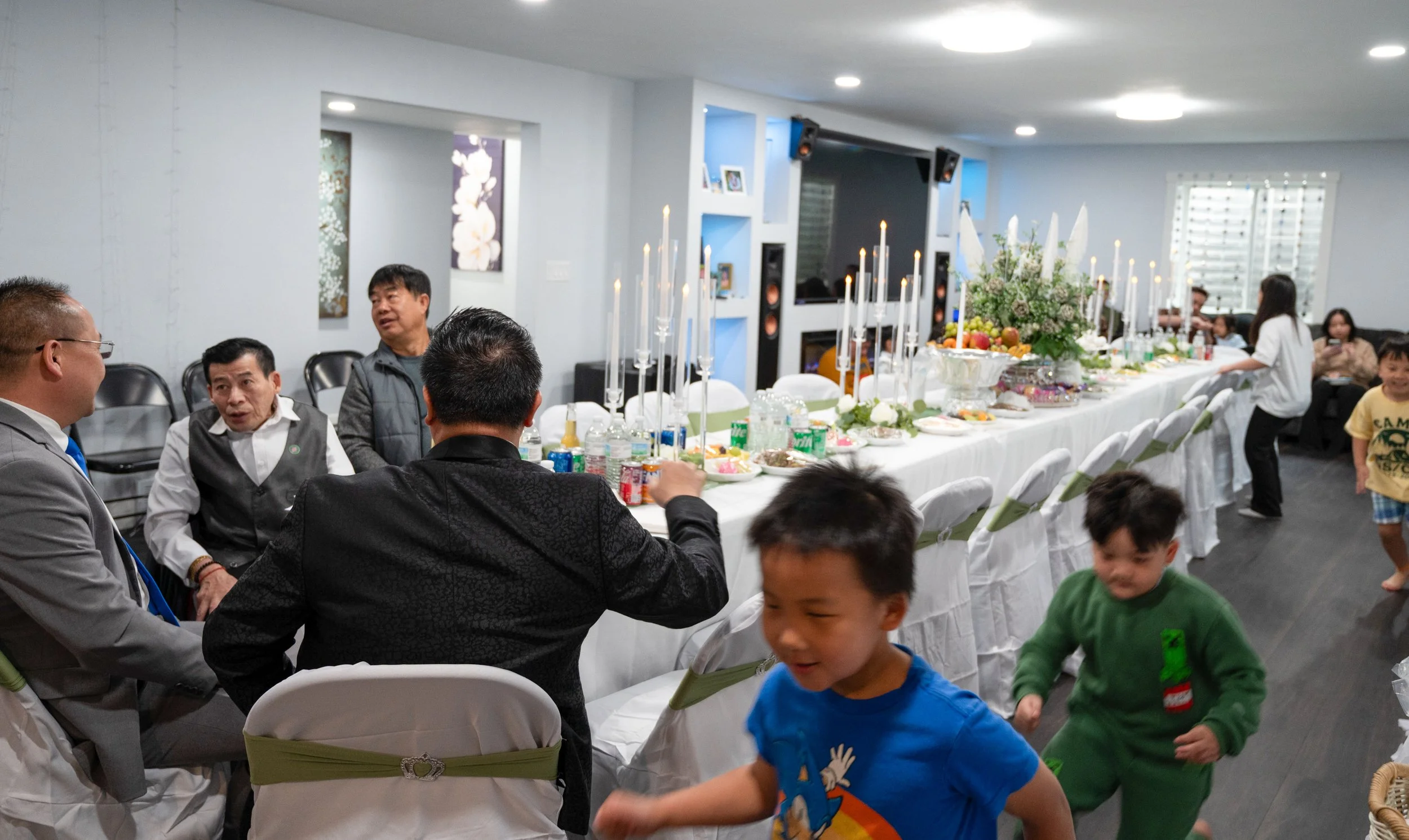 As older Hmong men discuss the logistics of the name change ceremony, young boys chase each other around the room in La Crosse, Wis., Saturday, April 18, 2026. At Hmong gatherings, it's common for children from many different families to play togethe