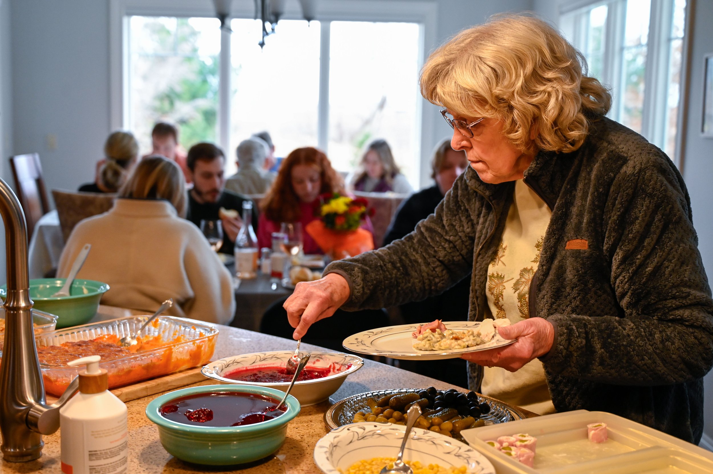 As the rest of the family sits down to eat their Thanksgiving dinner, Janet goes back to get a plate for herself. Each meal, she plates a meal for Chad before feeding herself. 