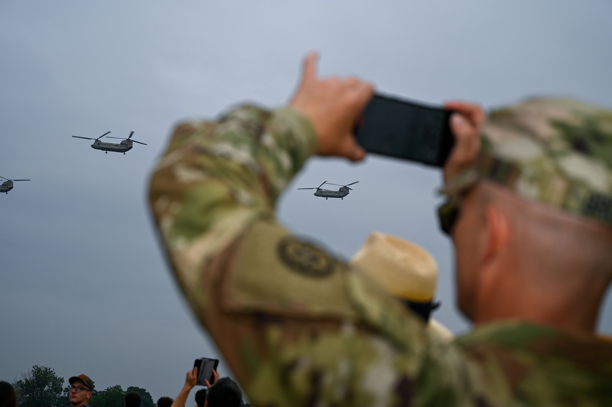 A U.S. Army soldier takes photos of aircraft flying by during the Army's 250th birthday celebration in Washington, D.C., on June 14, 2025.