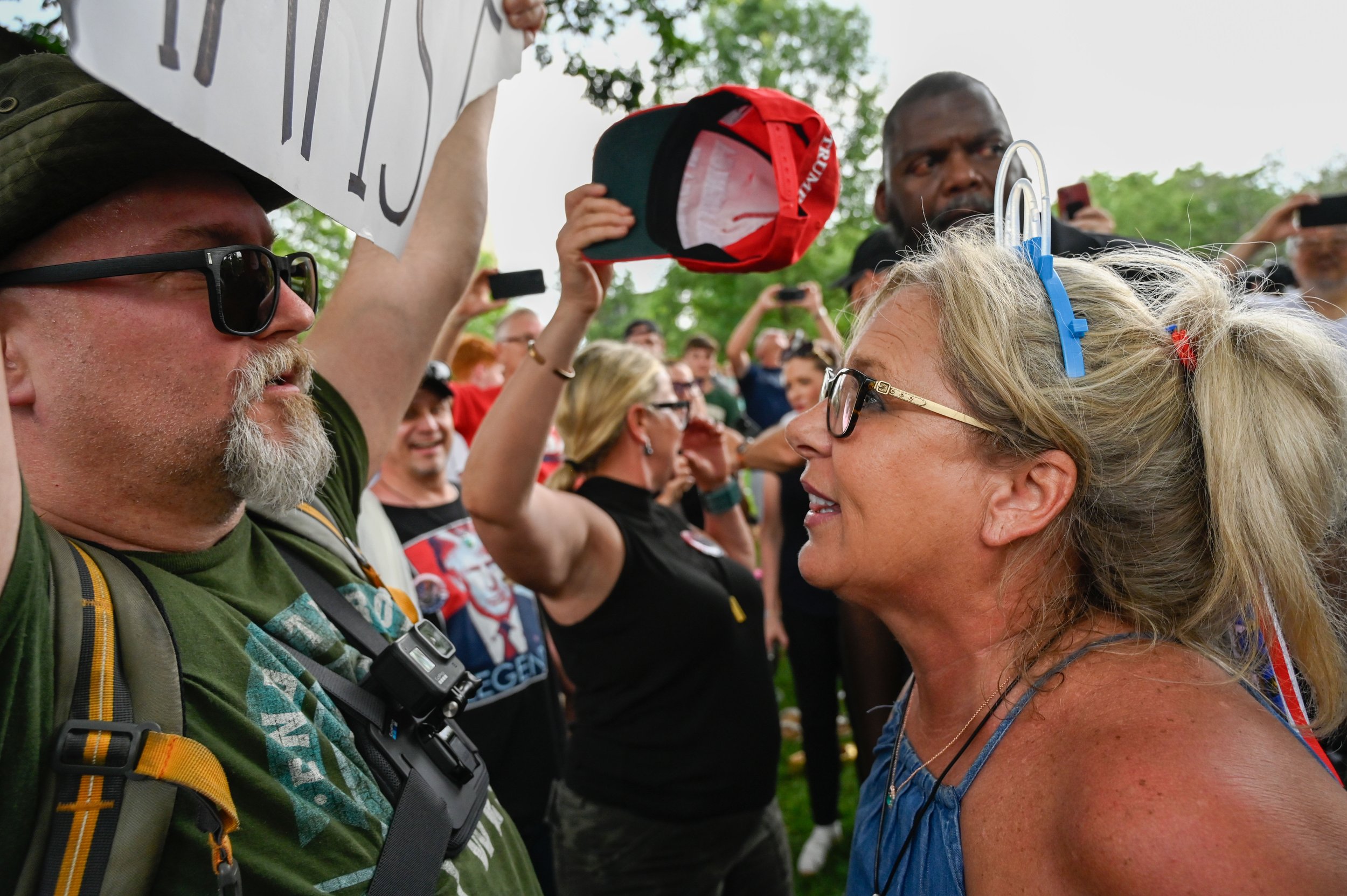 A woman confronts a protester who entered the Army's 250th birthday celebration and carried a sign stating "TRUMP IS A RAPIST" in Washington, D.C., on June 14, 2025.
