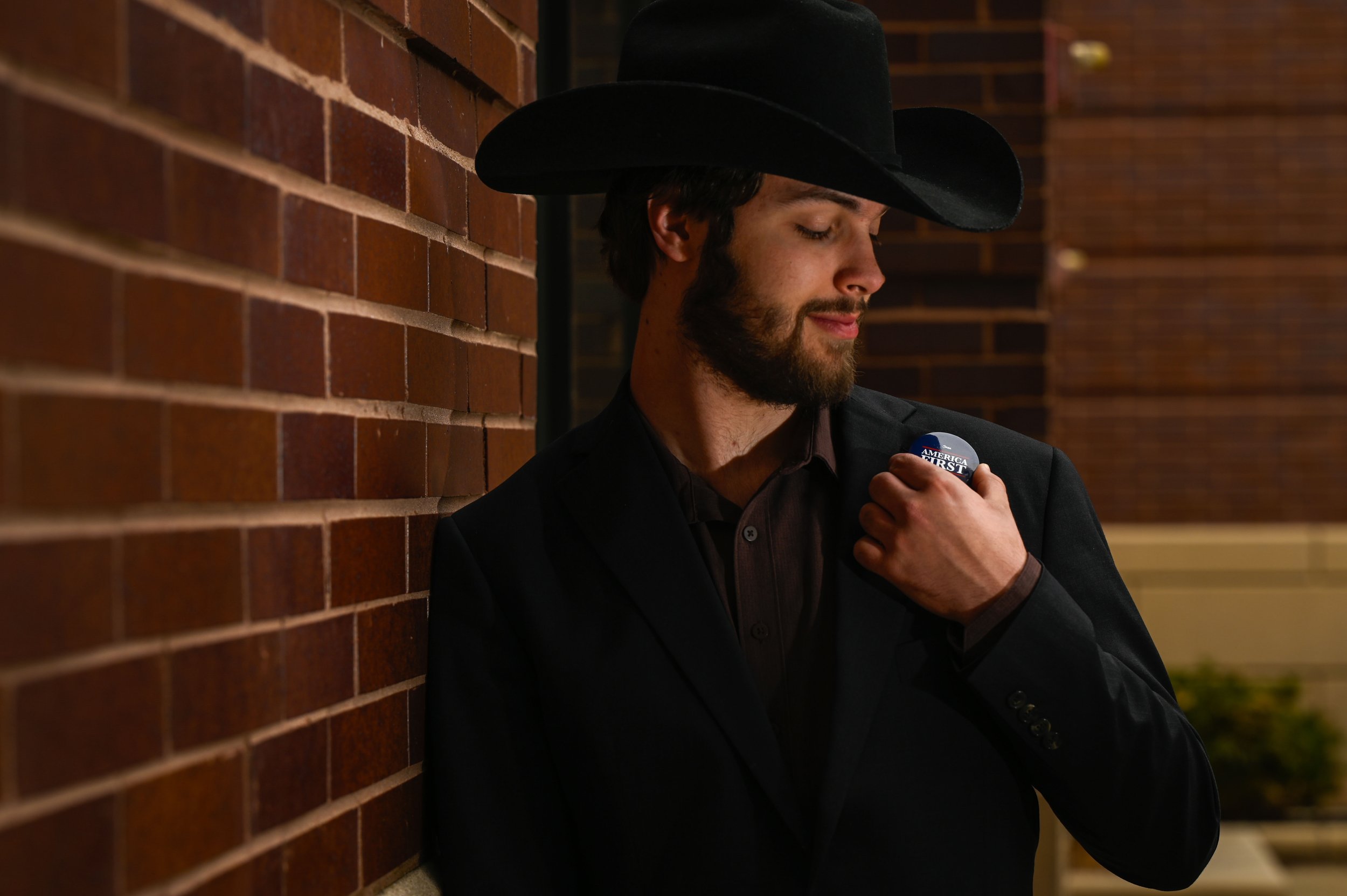 Marco Marchiando, a sophomore political science and history double major at UW-Oshkosh, looks at a pin signaling right-leaning viewpoints, in Oshkosh, Wisconsin, on April 9, 2025. Marchiando said he was a big fan of President Donald Trump targeting t