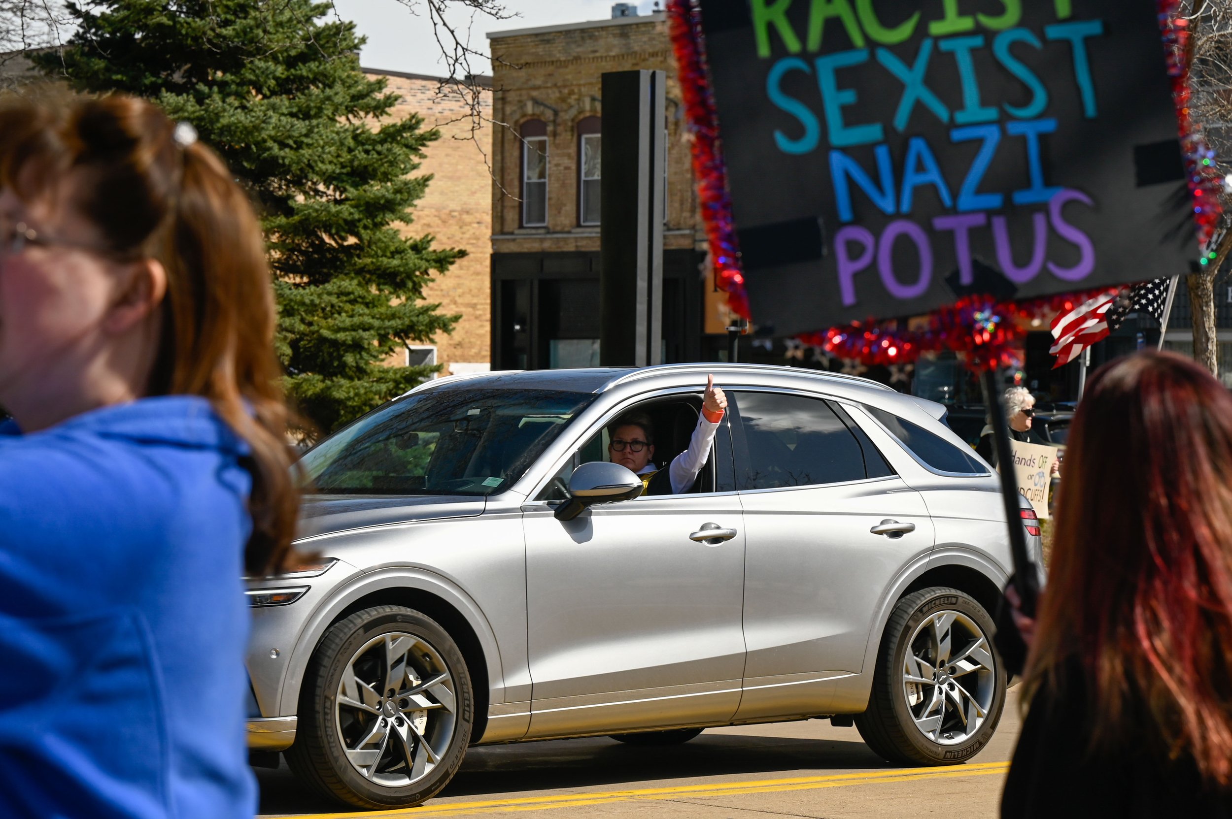A driver gives a thumbs up to protesters at the "Hands Off!" protest at Opera House Square in Oshkosh, Wisconsin on April 5, 2025. The driver spoke at the protest earlier that day. (Photo by Advance-Titan Photo Editor Jessica Duch)