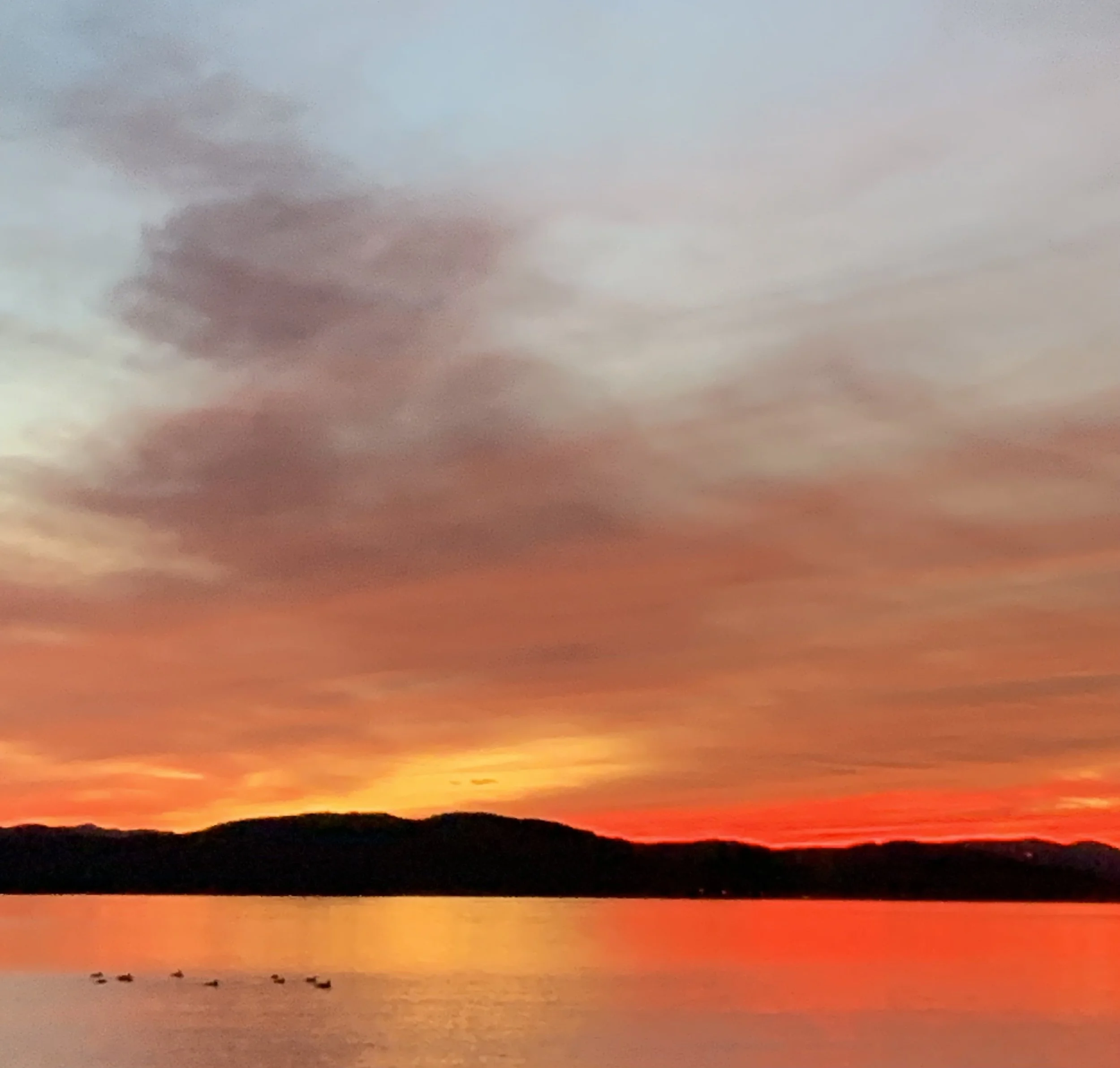 Bright orange sunset over a lake.