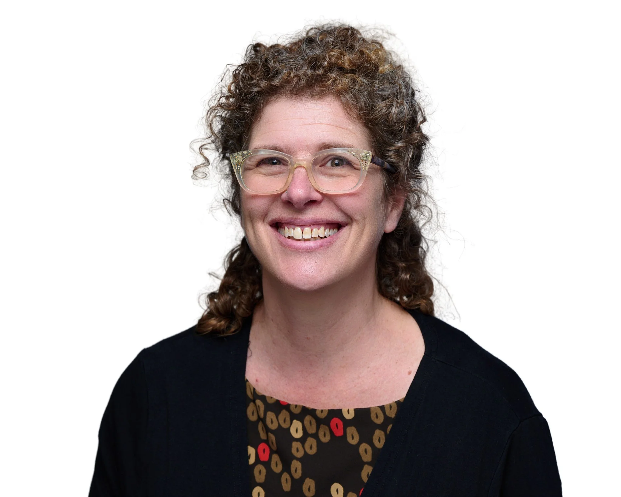 A head shot of Rachel Siegel, a white woman with curly brown hair and glasses smiles at the camera.