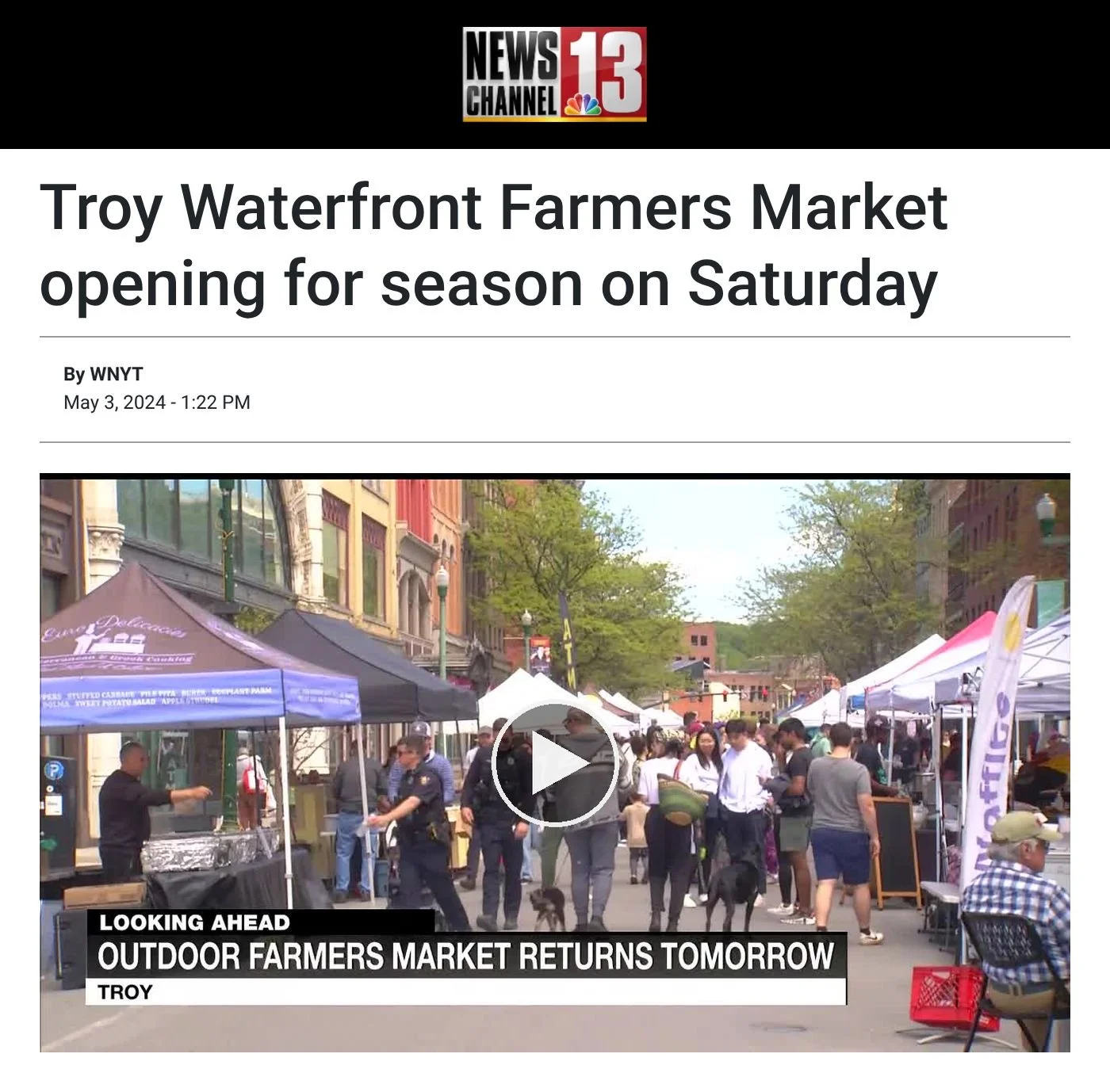 WNYT NewsChannel 13 website, May 3, 2024: ‘Troy Waterfront Farmers Market opening for season on Saturday’, with a video frame of shoppers among vendor tents on a downtown street, with the on-screen headline “Outdoor farmers market returns tomorrow”.