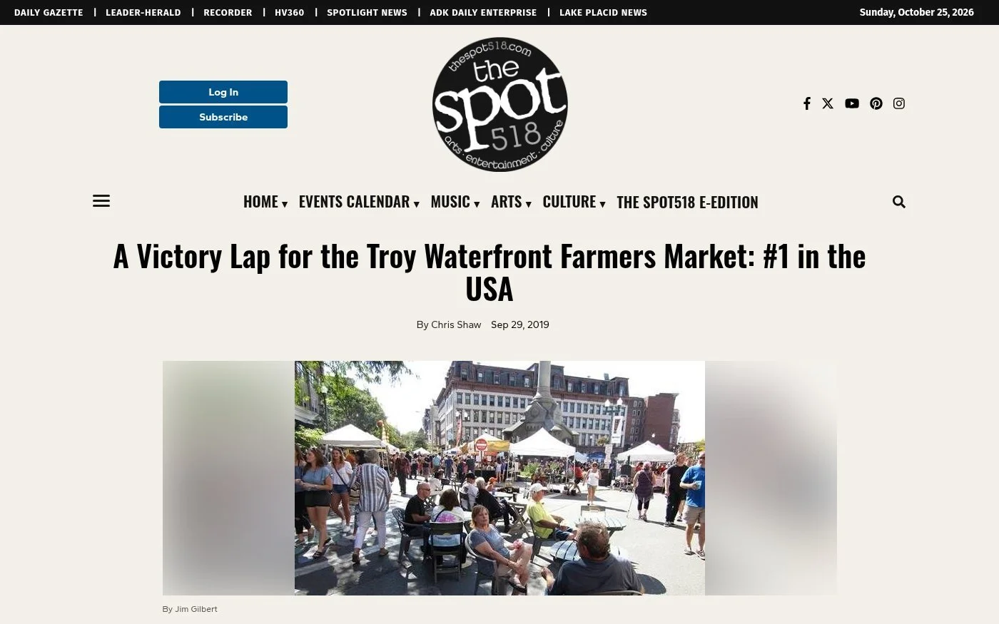 The Spot 518 website, Sept. 29, 2019: 'A Victory Lap for the Troy Waterfront Farmers Market: #1 in the USA' by Chris Shaw, with a photo by Jim Gilbert of shoppers seated at tables and crowding Monument Square among white vendor tents.