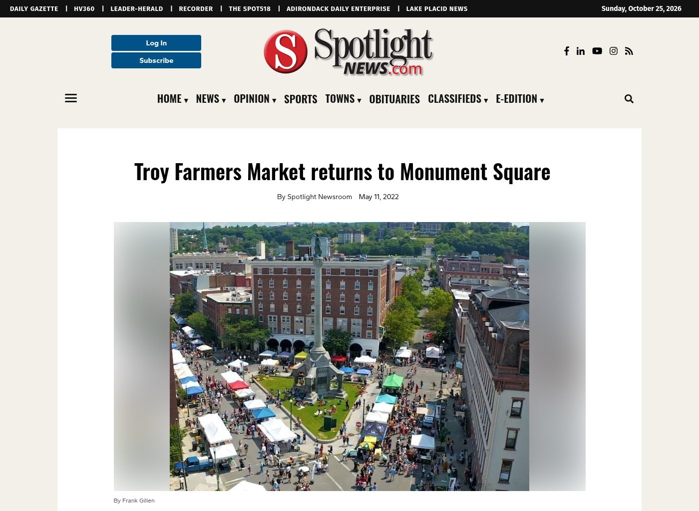 Spotlight News website, May 11, 2022: 'Troy Farmers Market returns to Monument Square' by Spotlight Newsroom, with an aerial photo by Frank Gillen of vendor tents and crowds filling the streets around the Monument Square column.