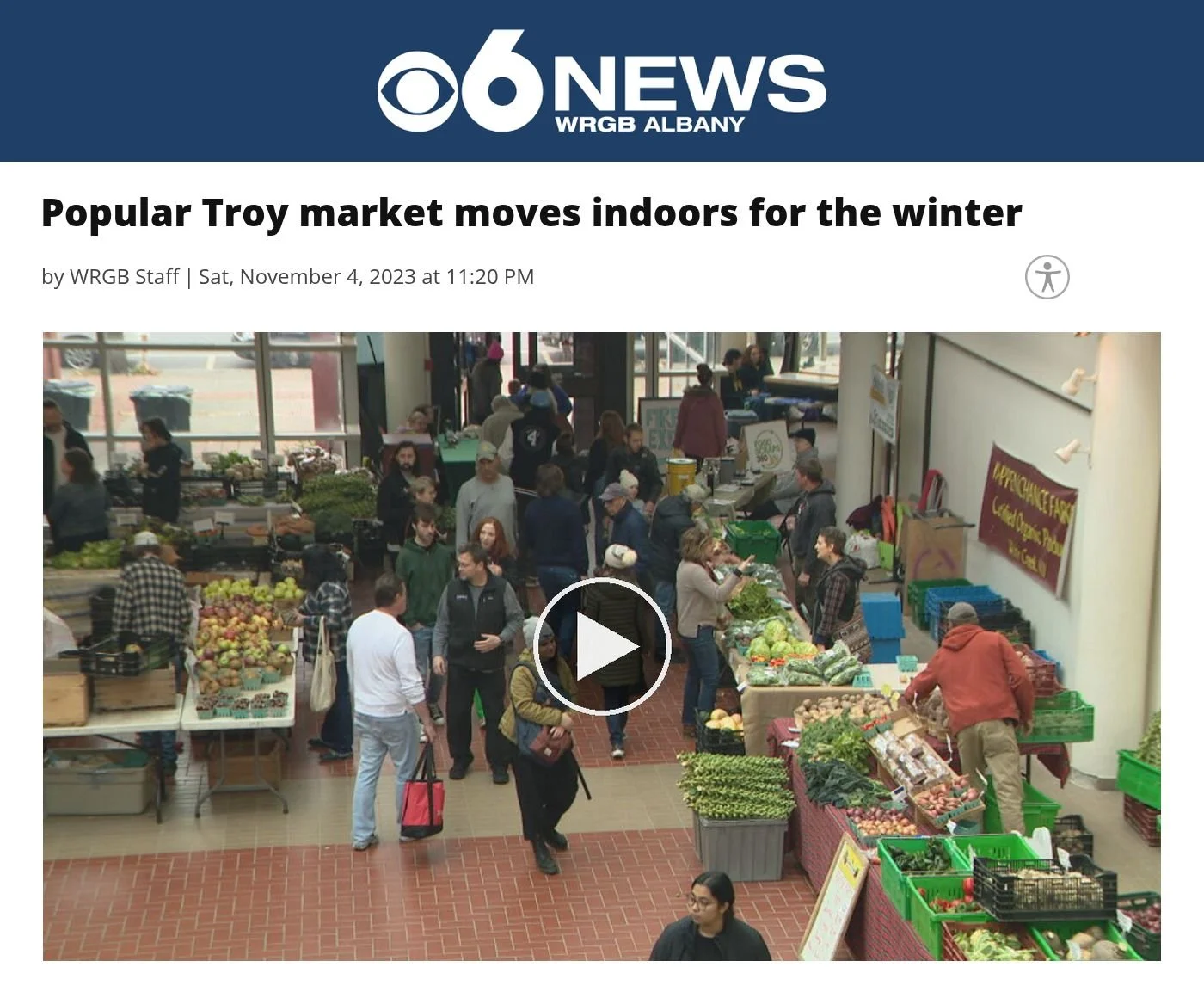 CBS6 Albany website, Nov. 4, 2023: ‘Popular Troy market moves indoors for the winter’, with a video frame of shoppers browsing produce stands at the indoor winter market.