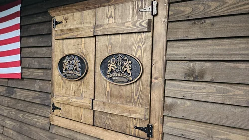 Wooden shutter with the black Bayern Haus emblem.