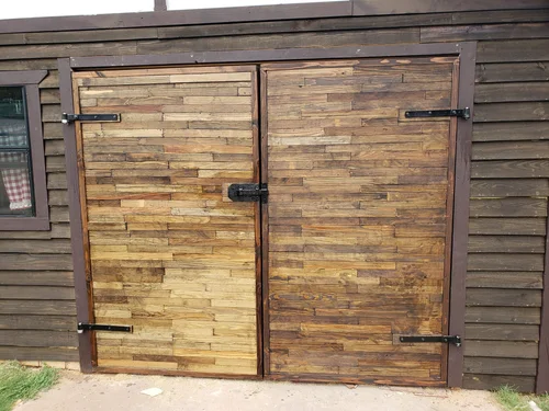 Finished wooden double door with black hardware.