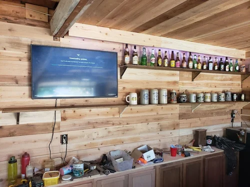 Wooden wall shelves with beer bottles and steins.
