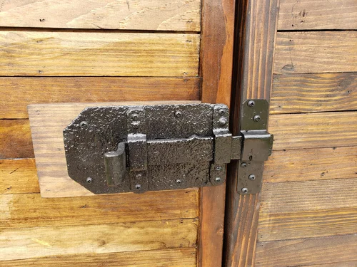 Black metal bolt on the wooden door.