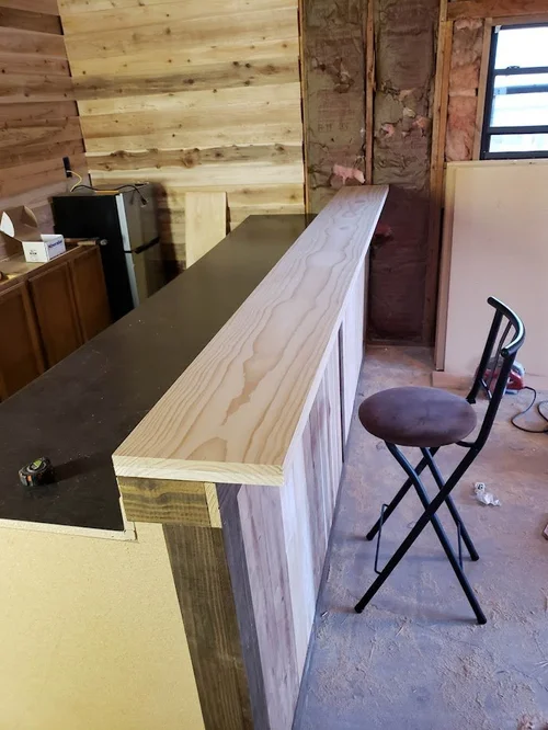 Wooden counter with tools and materials during construction.