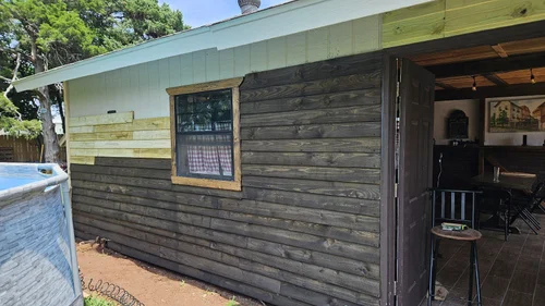 The wood-clad cabin exterior with the door open to the living room.