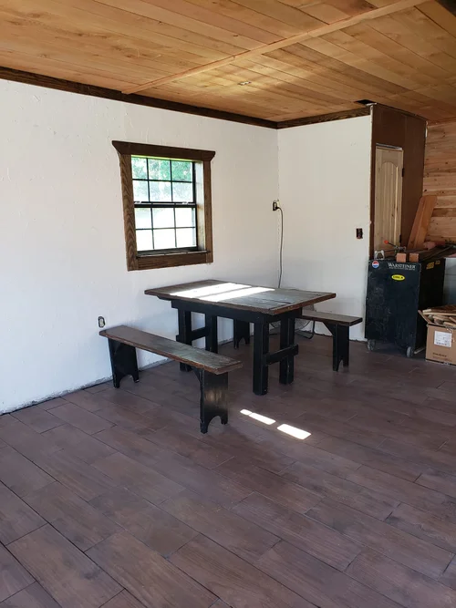 Wood-paneled room with a rustic table and two benches.