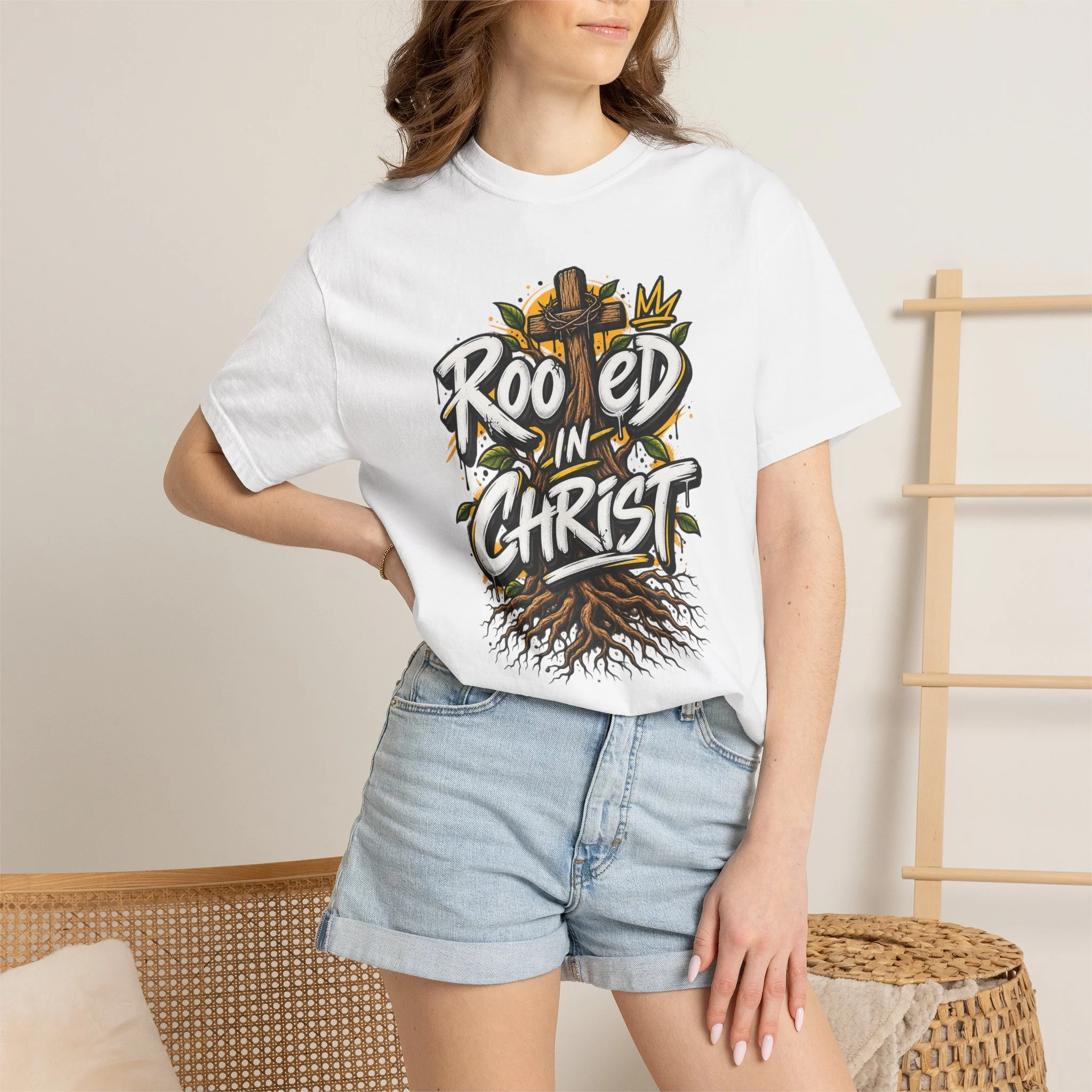 Unisex white t-shirt featuring a vibrant graffiti-style 'Rooted in Christ' design with a cross, tree roots, and a crown.