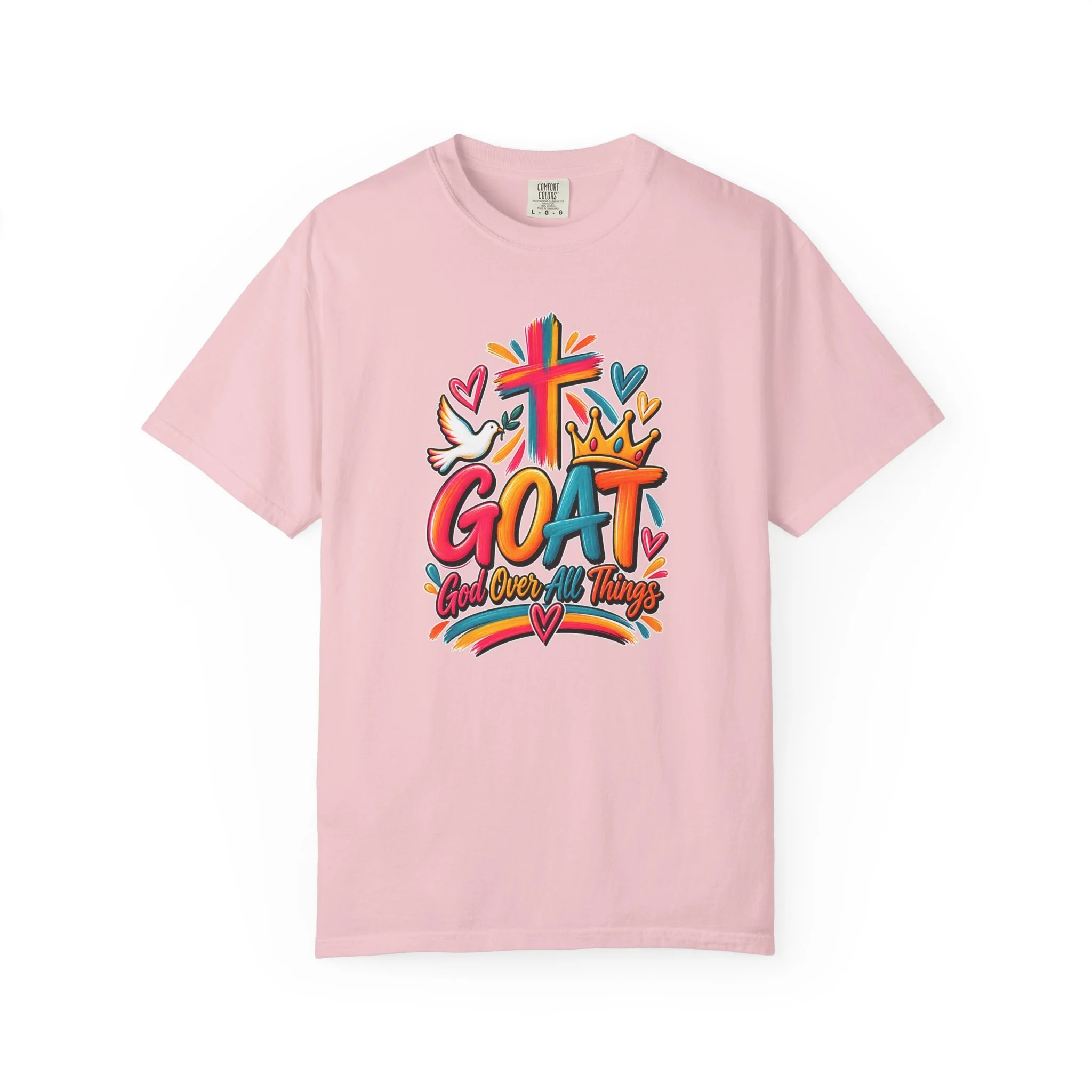 Light pink unisex t-shirt graphic showing bright, colorful modern script that reads GOAT and "God Over All Things", accented with a painted cross, crown, hearts, and a dove.