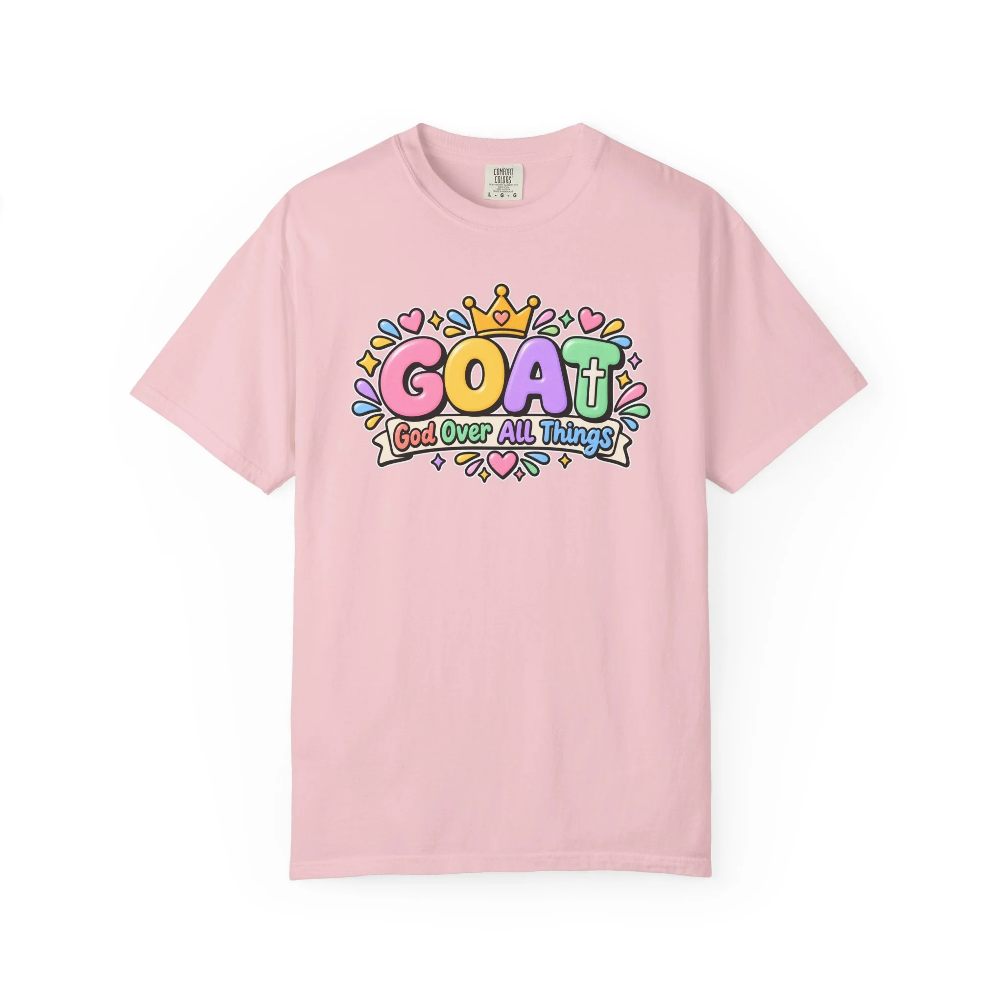 Light pink unisex t-shirt graphic showing cute 3D pastel bubble letters spelling GOAT, a yellow crown with a heart, hearts, sparkles, and a banner below that reads "God Over All Things".