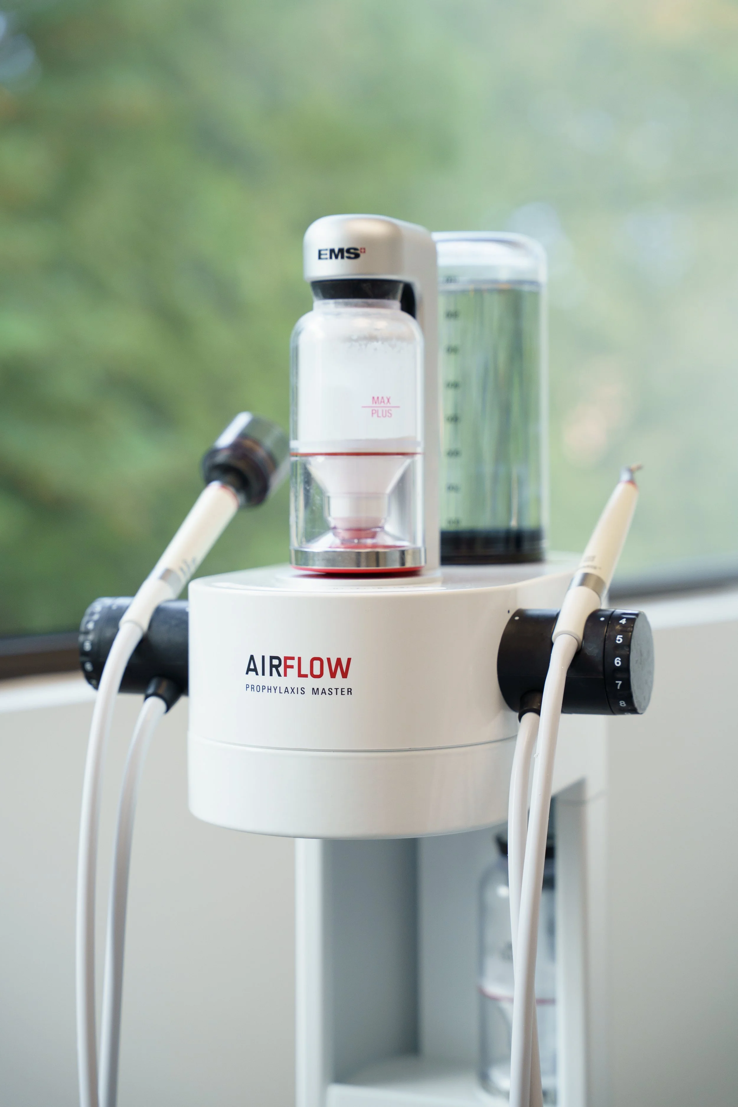 Medical device with hoses and bottles, labeled 'AIRFLOW PROPHYLAXIS MASTER', used for dental cleaning or oral care treatment.