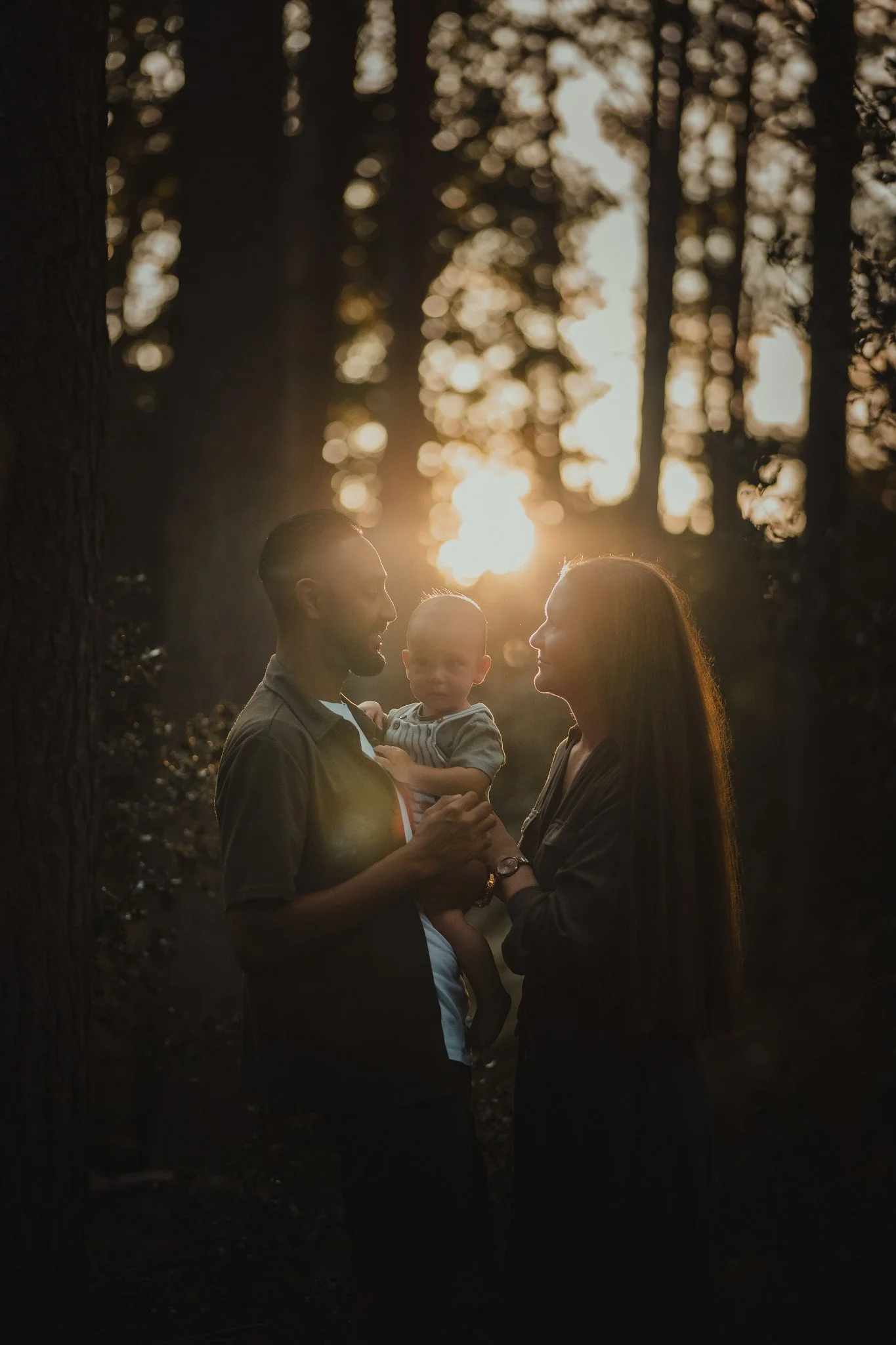 Creative family portrait at sunset in the woods with baby
