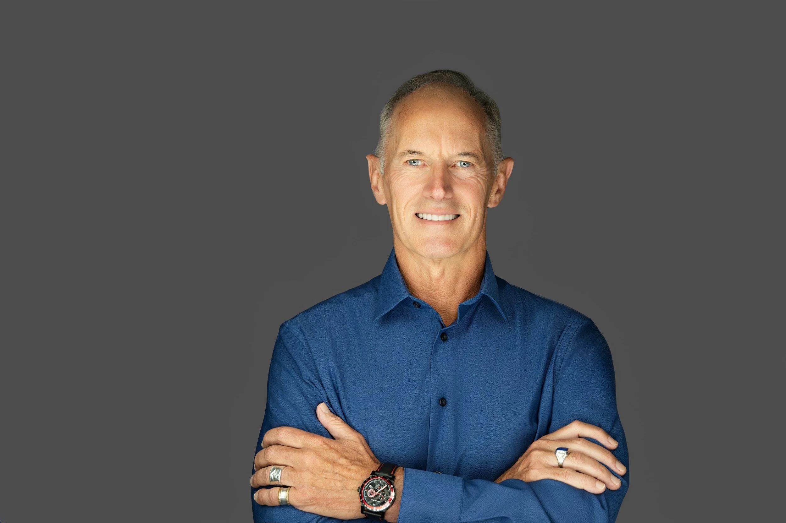 Executive headshot of a man in a fitted solid blue shirt with a watch and rings, photographed by Yevette Lynn Photography in Kingsport, Tennessee