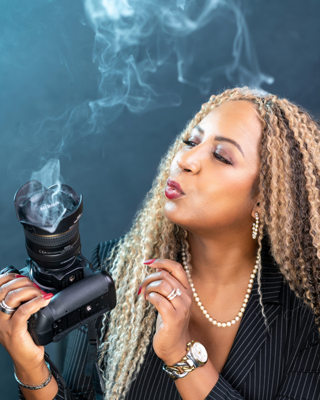 Yevette Lynn branding portrait photographer captured interacting with camera and drifting smoke, creative studio headshot highlighting artistic vision and personal brand identity.