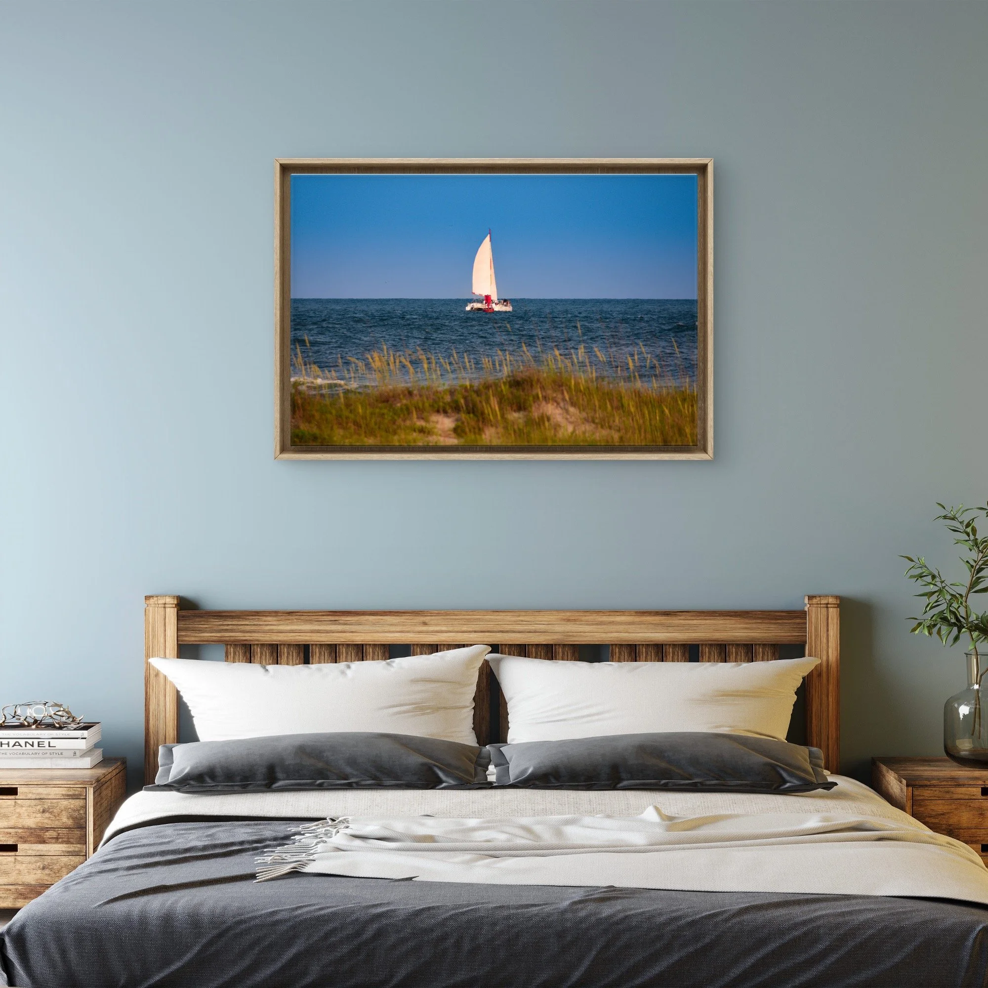Coastal seascape with a distant sailboat beyond grassy dunes, photographed in natural light by Yevette Lynn, fine art photography print