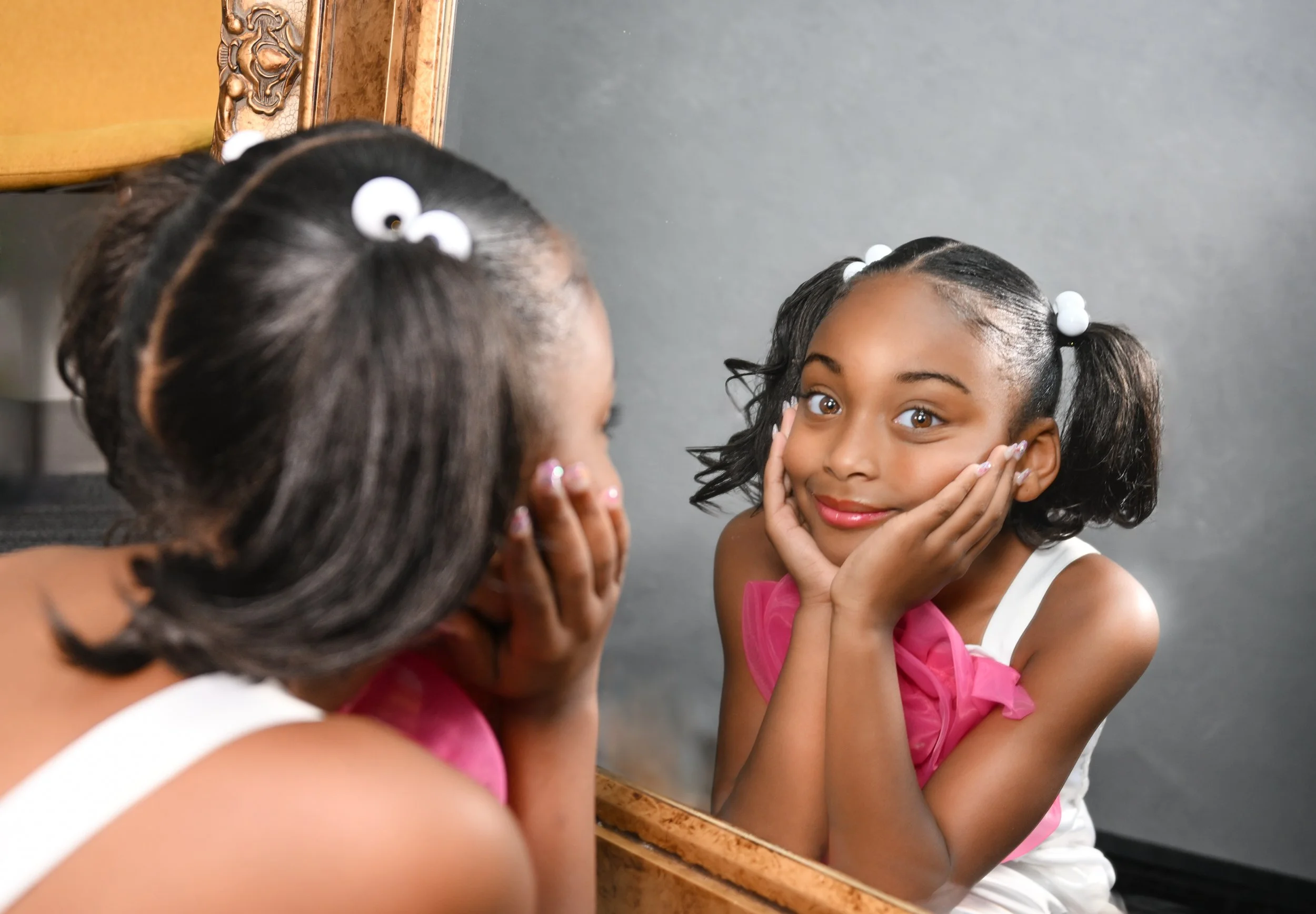 Mother's Day photo shoot with little girl looking in the mirror at herself