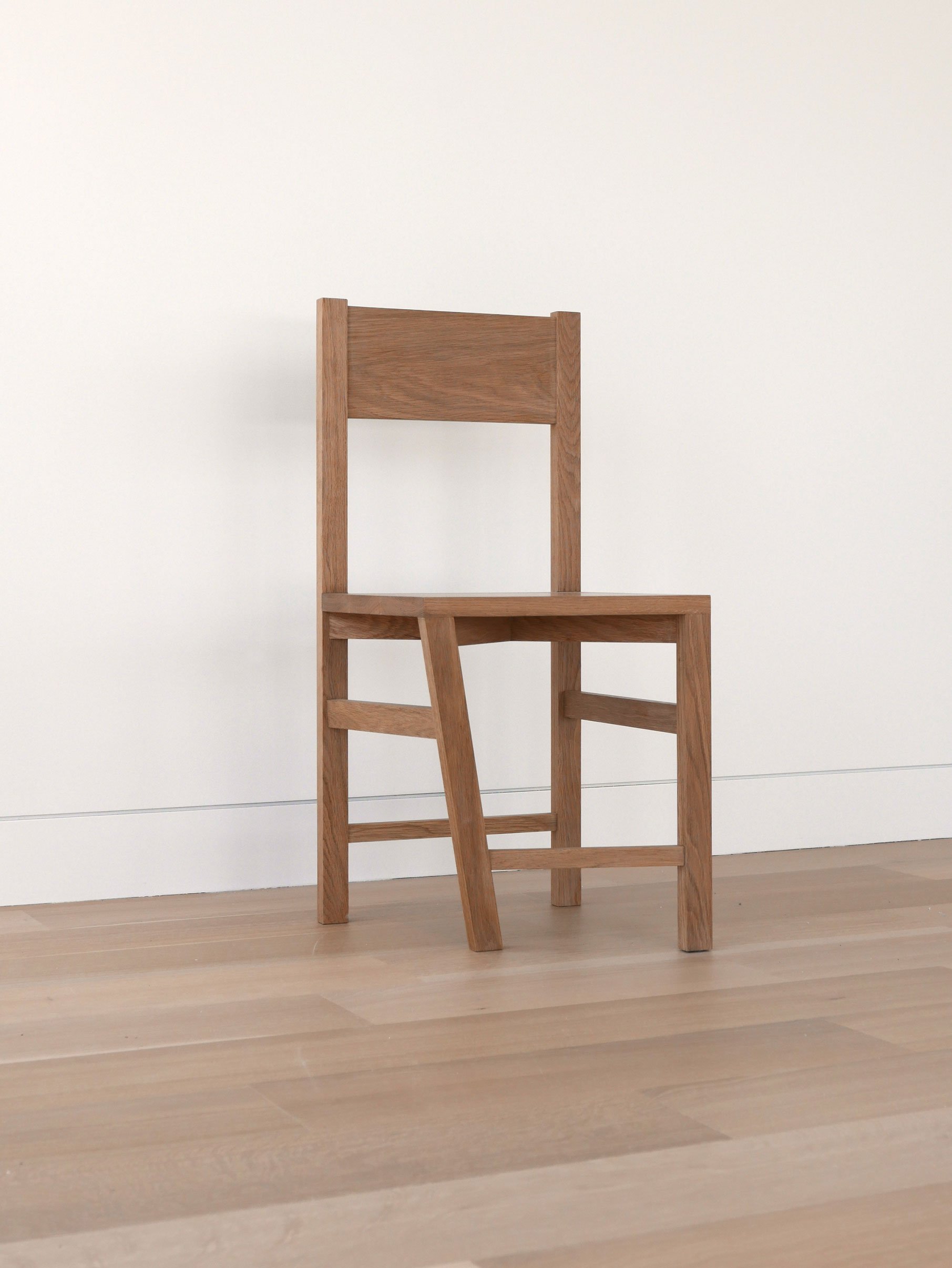 The 'Paradox of the Typical Atypical' chair. The chair's singular deviating leg inspires contemplation on the nature of normativity and eccentricity.