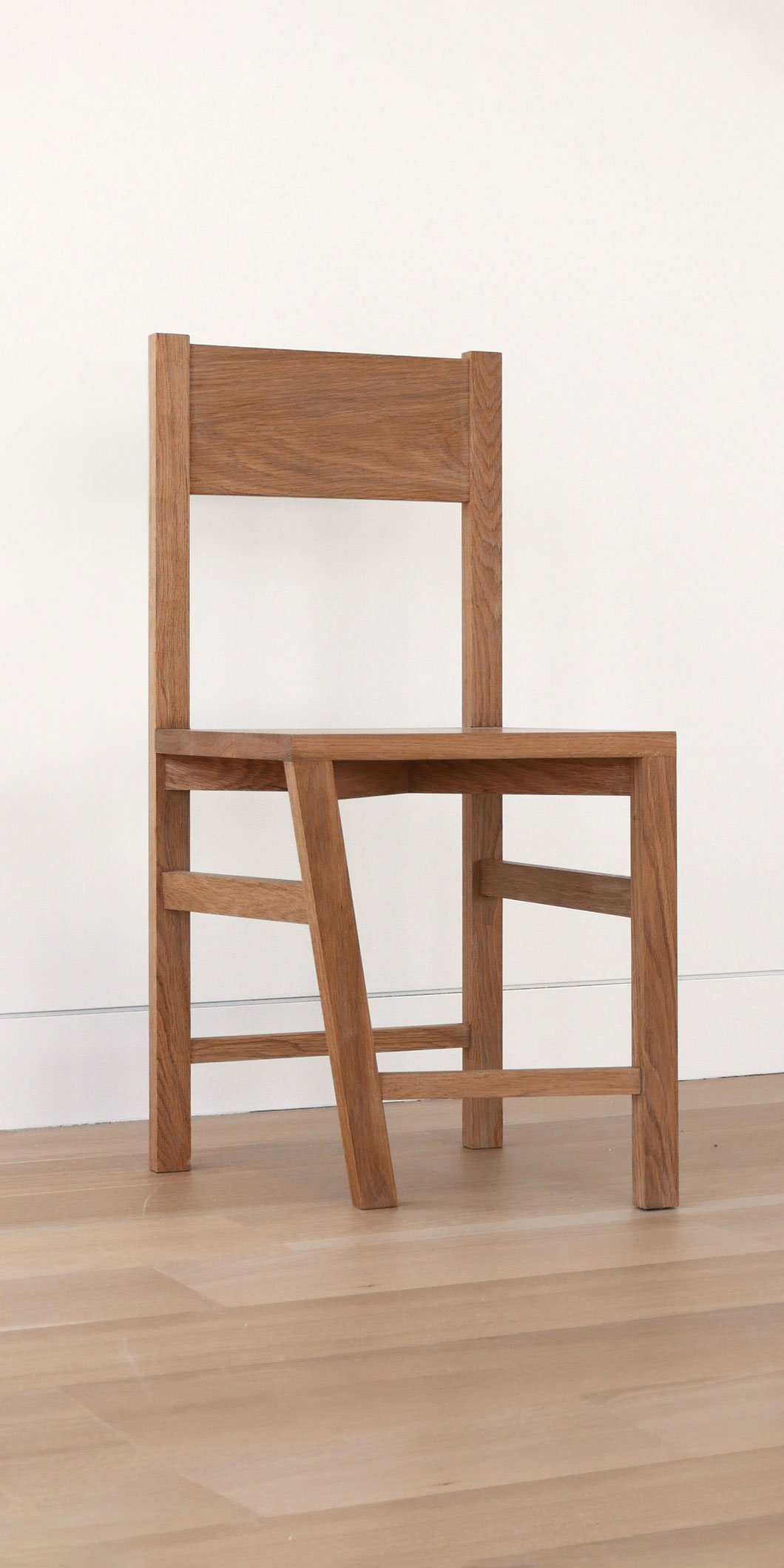 The 'Paradox of the Typical Atypical' chair. The chair’s customary form is innovatively tweaked with a skewed leg, symbolizing the bridging of mundane and extraordinary.