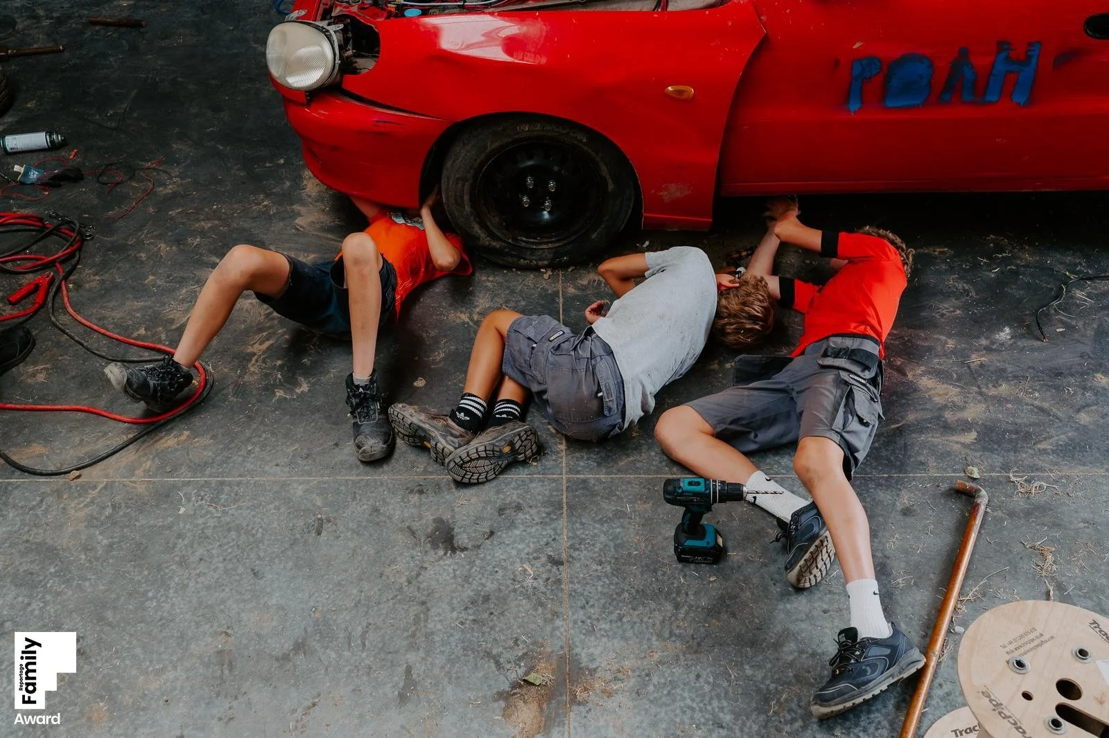 3 jongens sleutelen aan hun auto tijdens een gezinsreportage thuis