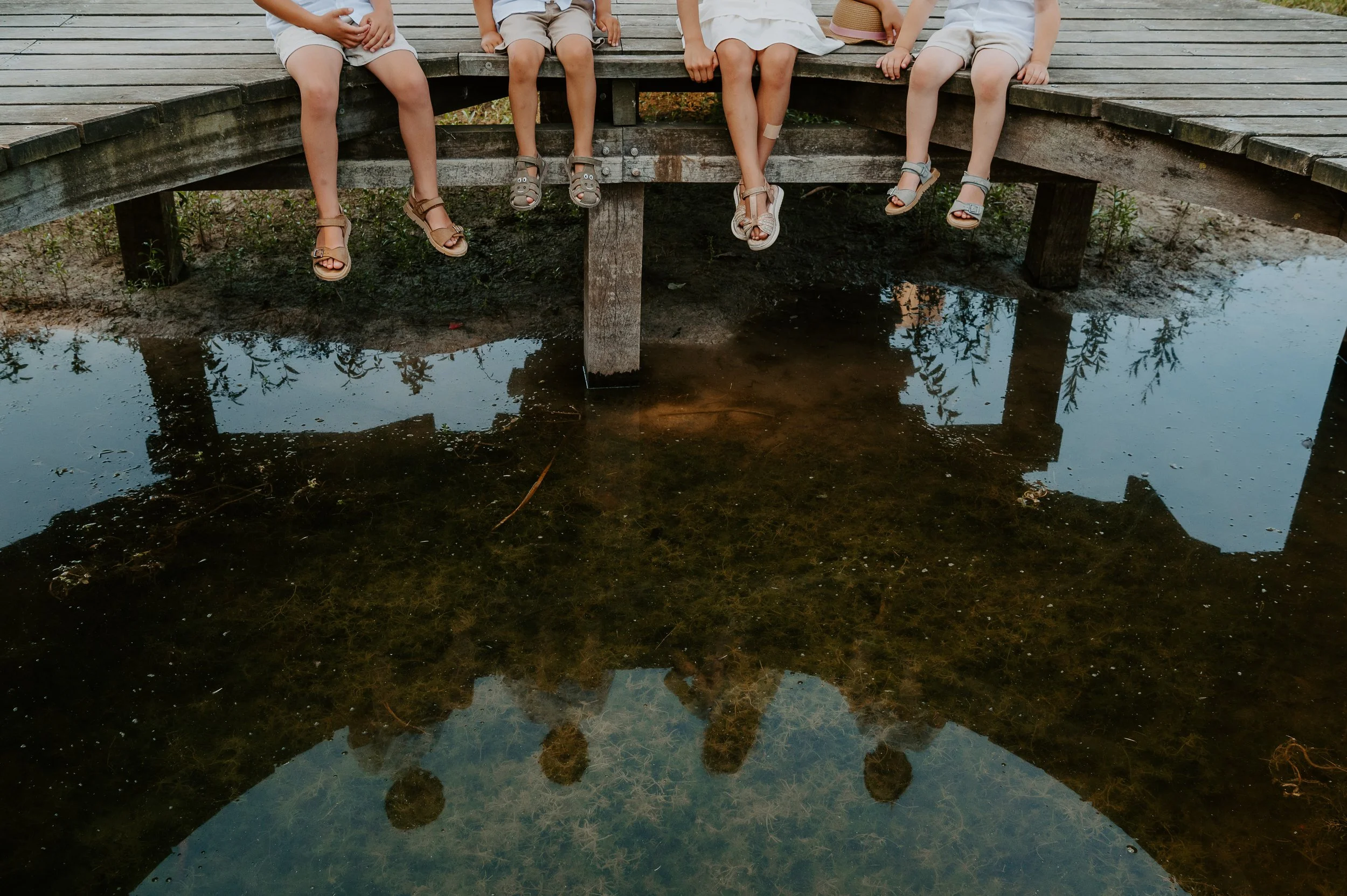 kleinkinderen die zitten aan het water tijdens een familiereportage op een spontane manier tijdens een uitstapje naar de gavers
