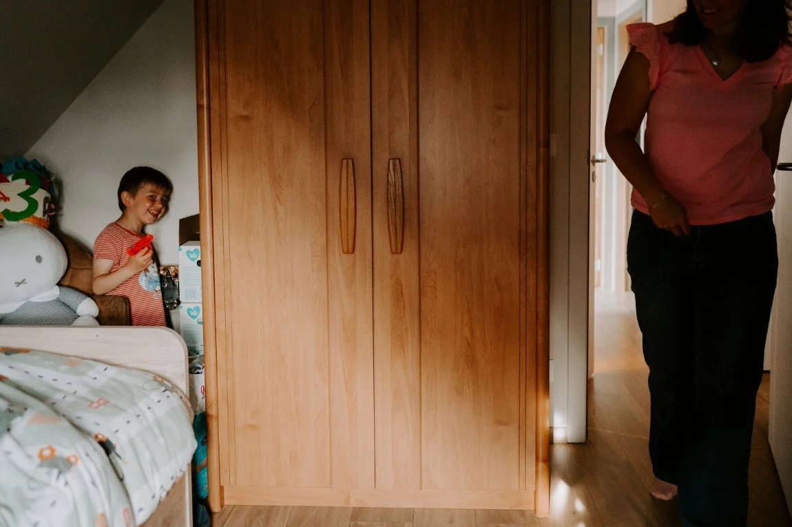 een jongen verstopt zich in zijn kamer voor mama die eraan komt. 
