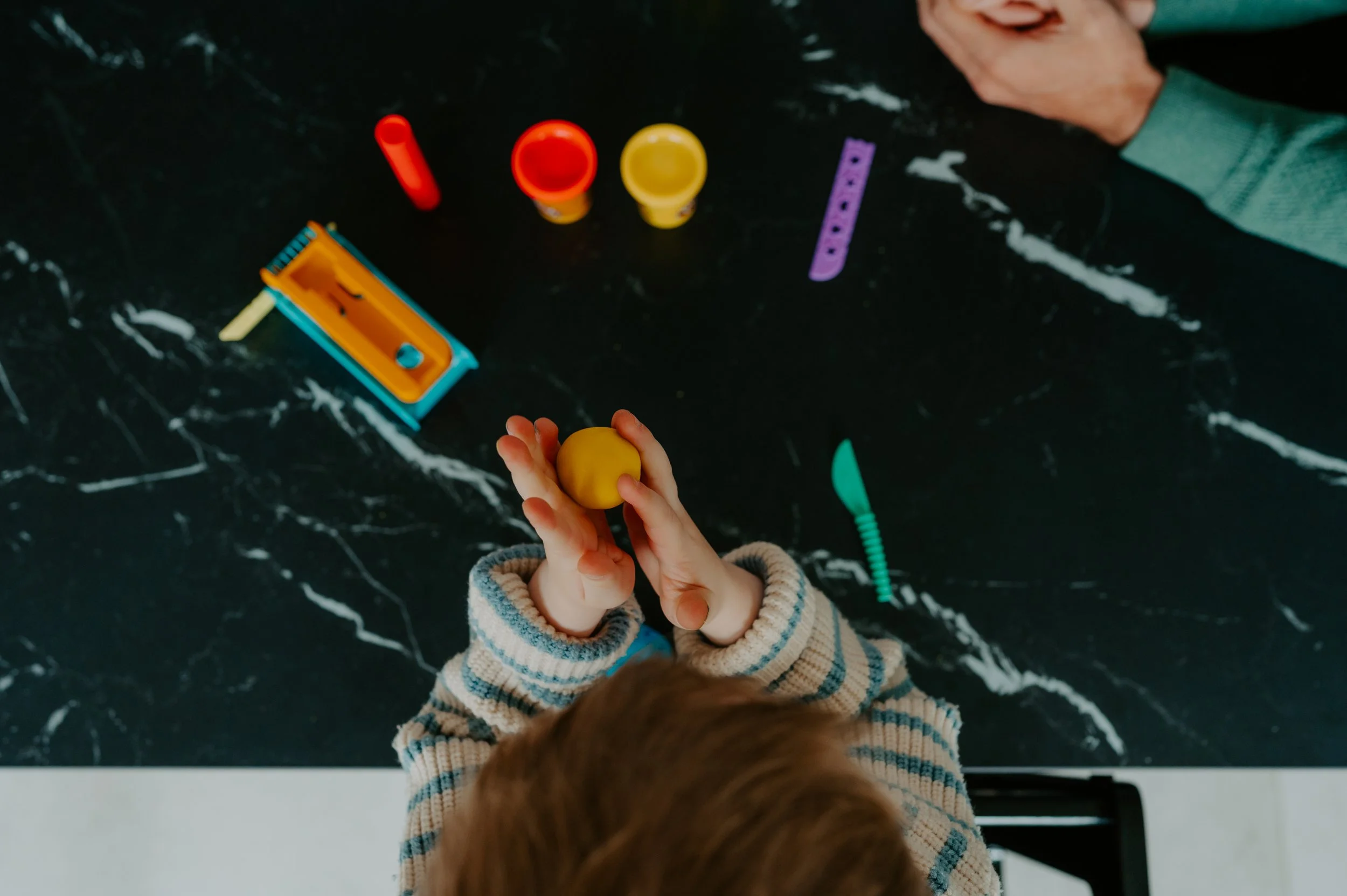 2 kleine kinderhandjes die aan het boetseren zijn 