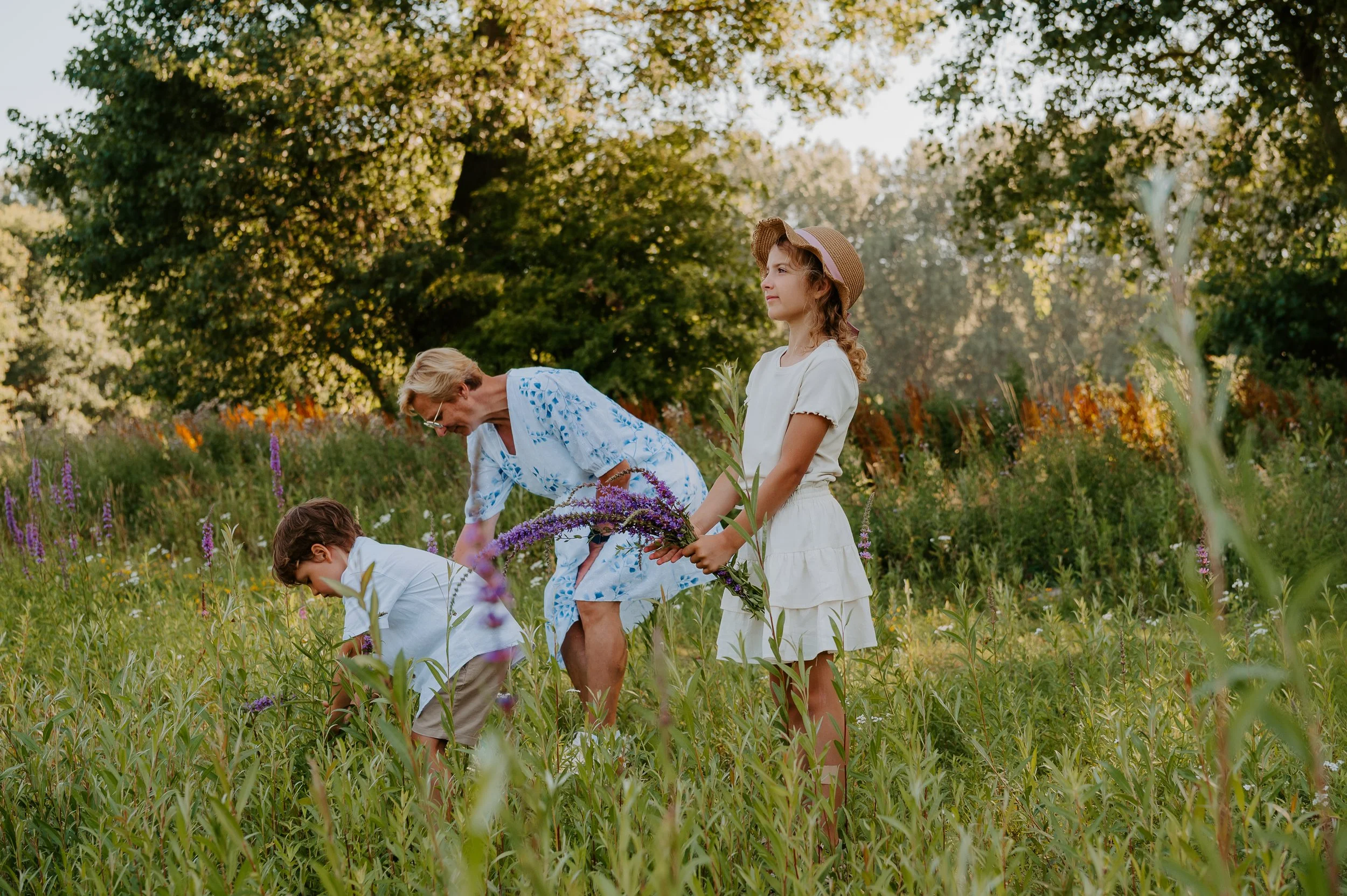 oma plukt bloemen met kleindochter voor een foto voor de familieshoot
