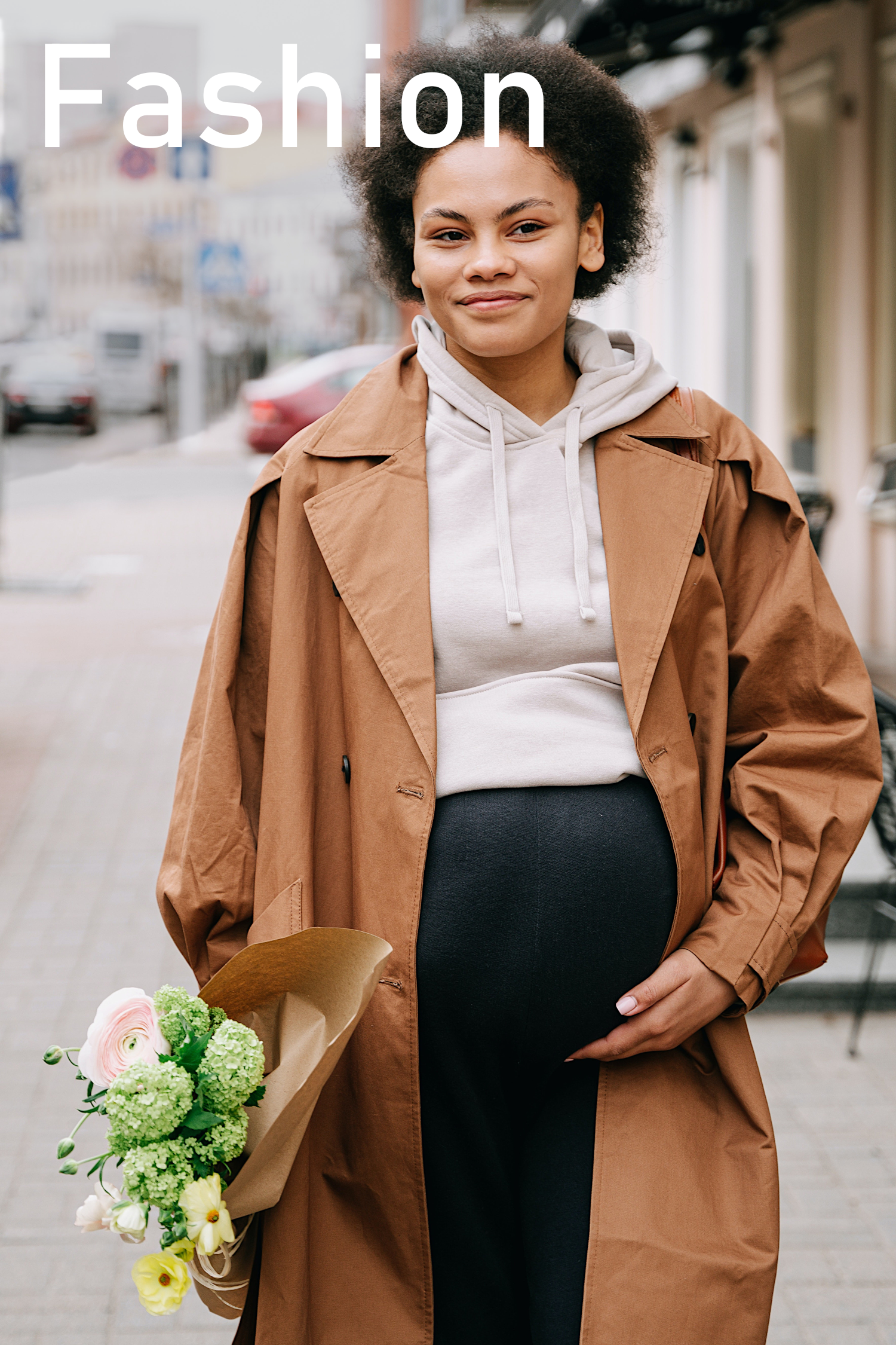 Pregnant Mom Walking Outdoors in City Scene Wearing Maternity Clothes of a White Hooded Top and Black Pants. She is Also Wearing a Brown Overcoat and Holding Flowers. The Word Fashion Appears On the Top Left Corner of the Image.