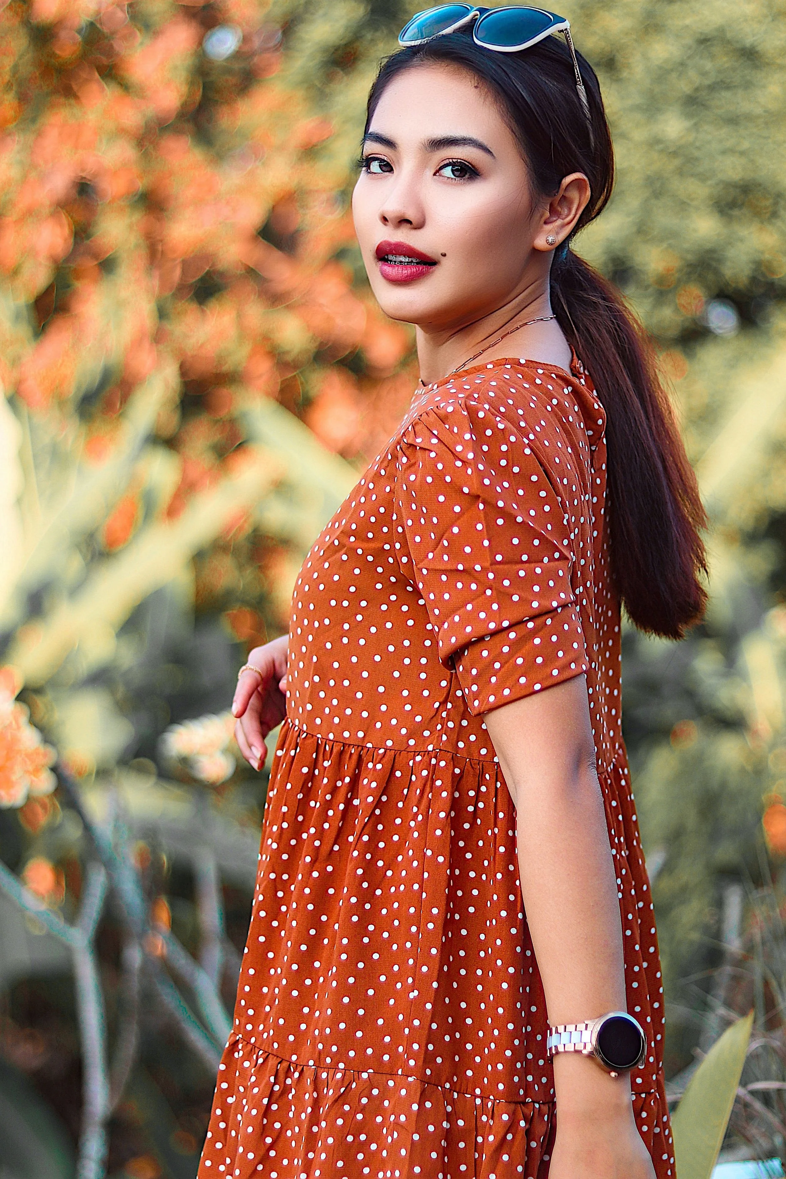 Woman Walking Outdoors Wearing Orange Maternity Dress.