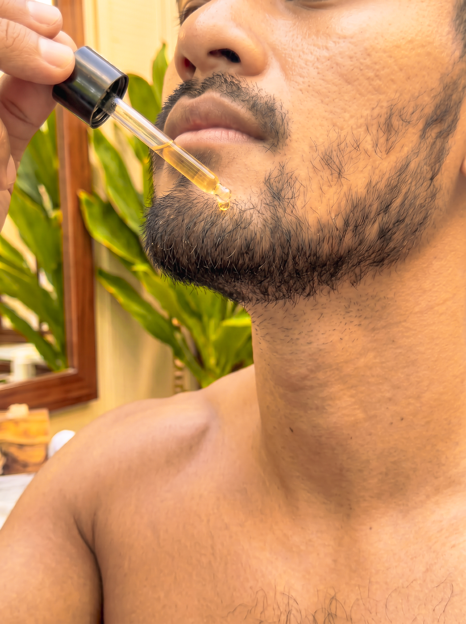 a male model showing the application of Kekoa Creative natural beard oils to his face and beard