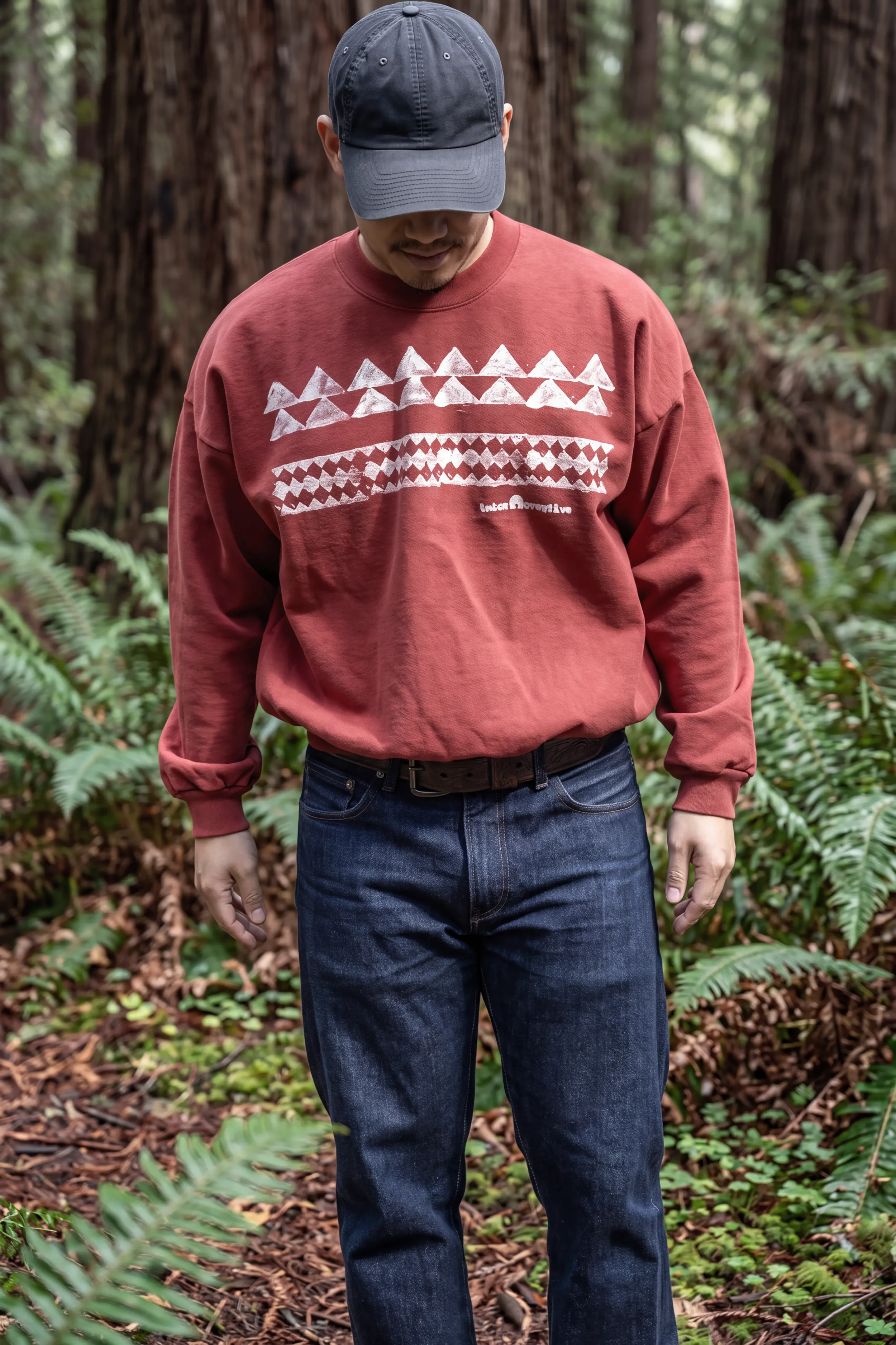 Model wearing unisex ʻŌhelo Red He Mano Ka Niho drop-shoulder boxy trash crewneck sweatshirt in 100% reclaimed waste cotton by Kekoa Creative.