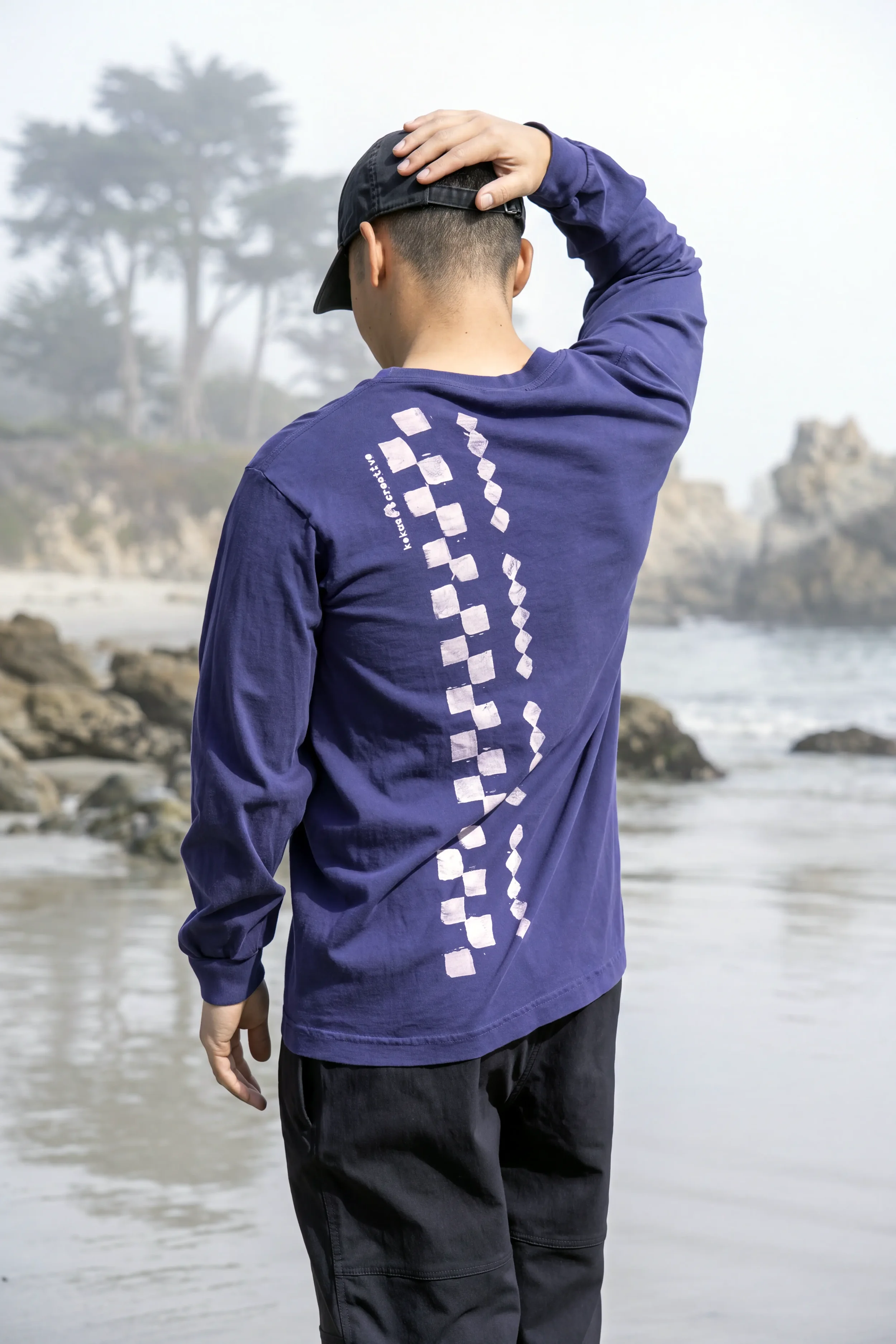 Back view of Dark Navy Kōnane long sleeve trash tee featuring vertical lālani column discharge print with zero hand feel.